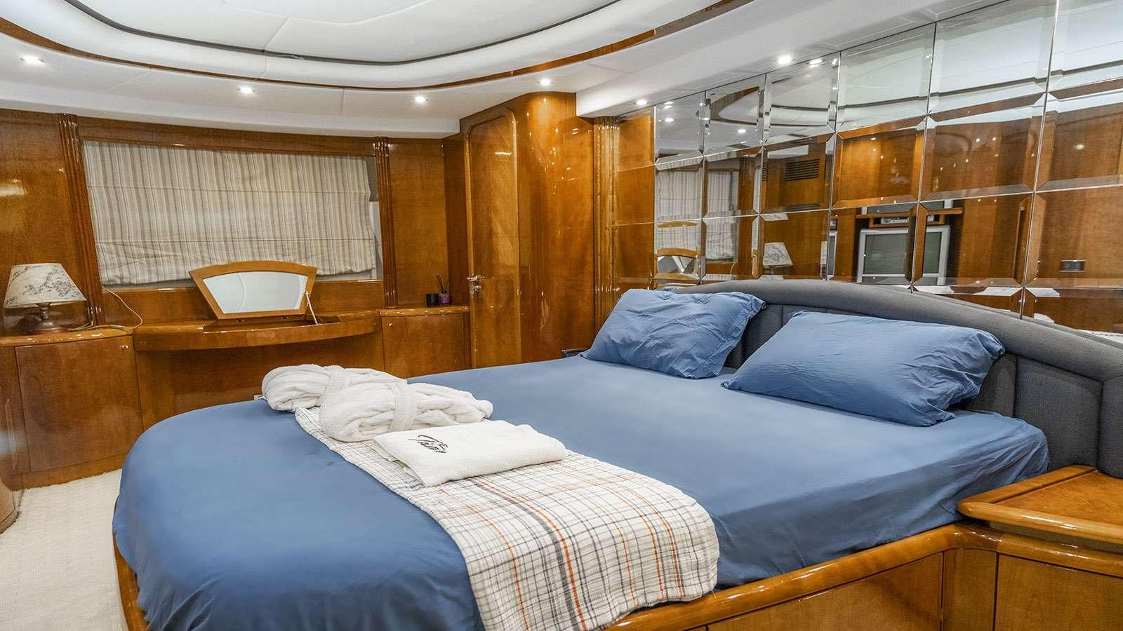 a room with a bed and a wood wall aboard TITAN Yacht for Charter