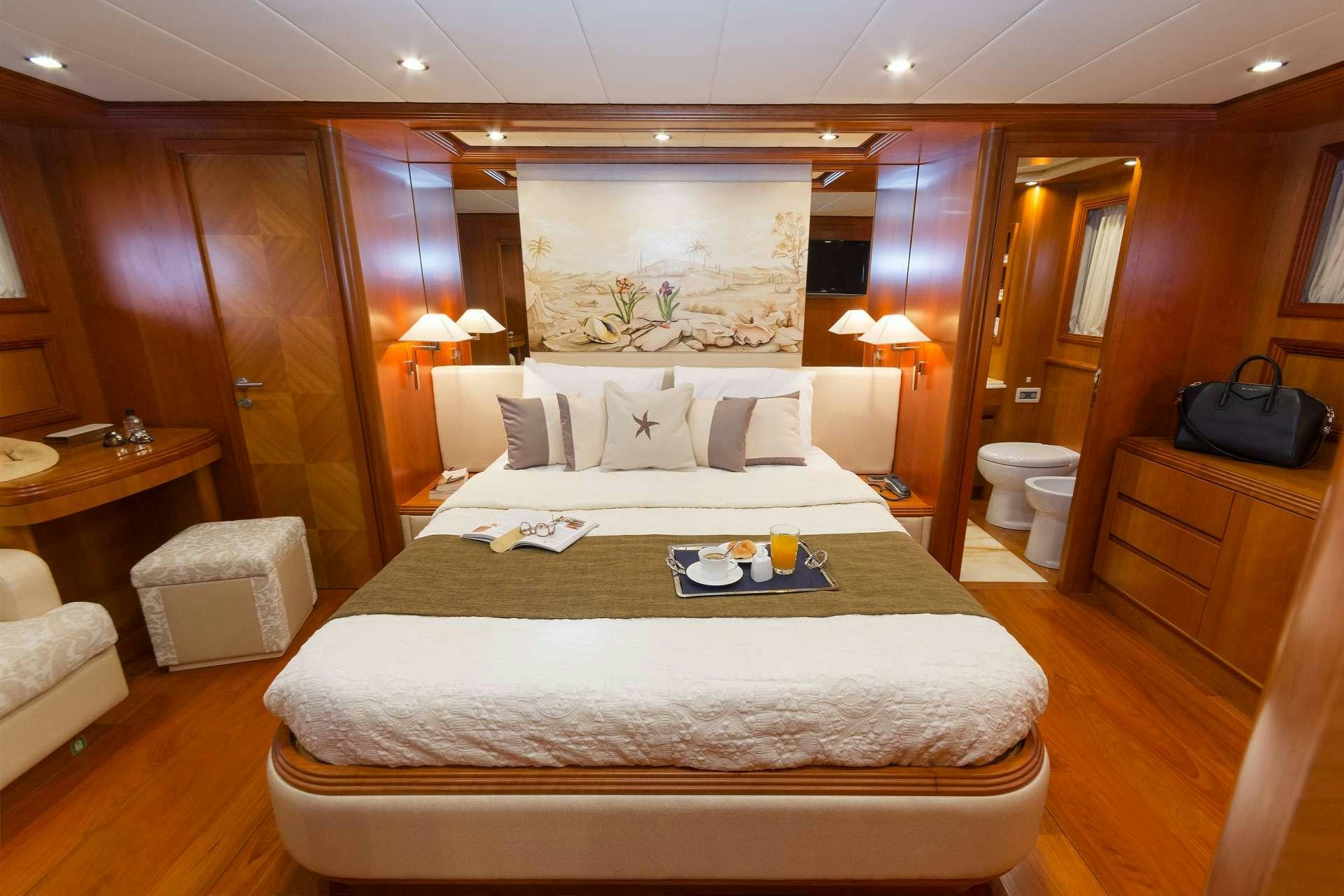 a hotel room with a bed and a table aboard ALFEA Yacht for Charter
