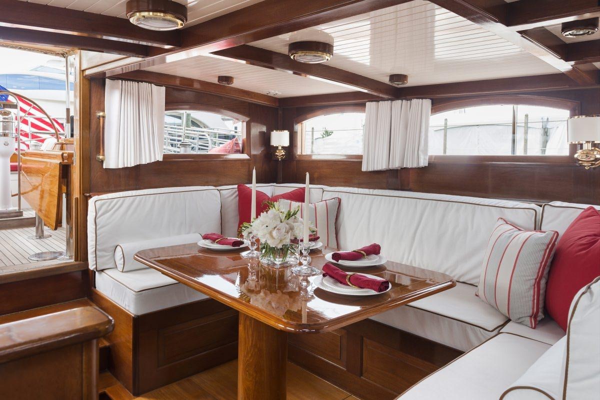 a table with plates and flowers in a room with a window aboard NORTHERN STAR Yacht for Charter