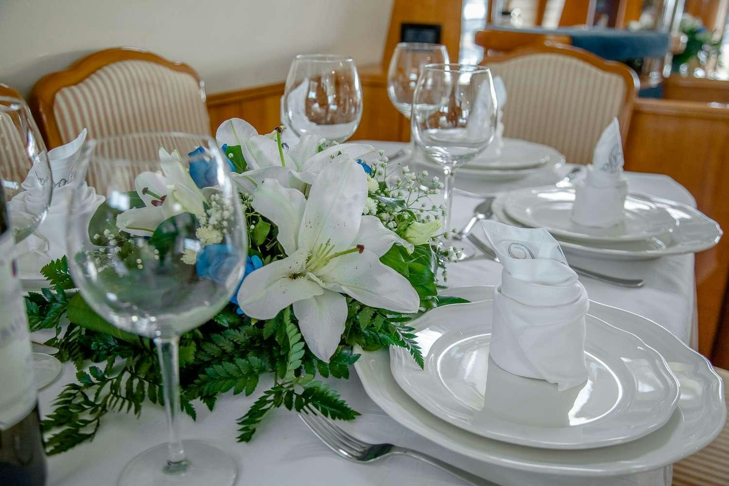 a table set with white flowers aboard GODSPEED Yacht for Charter