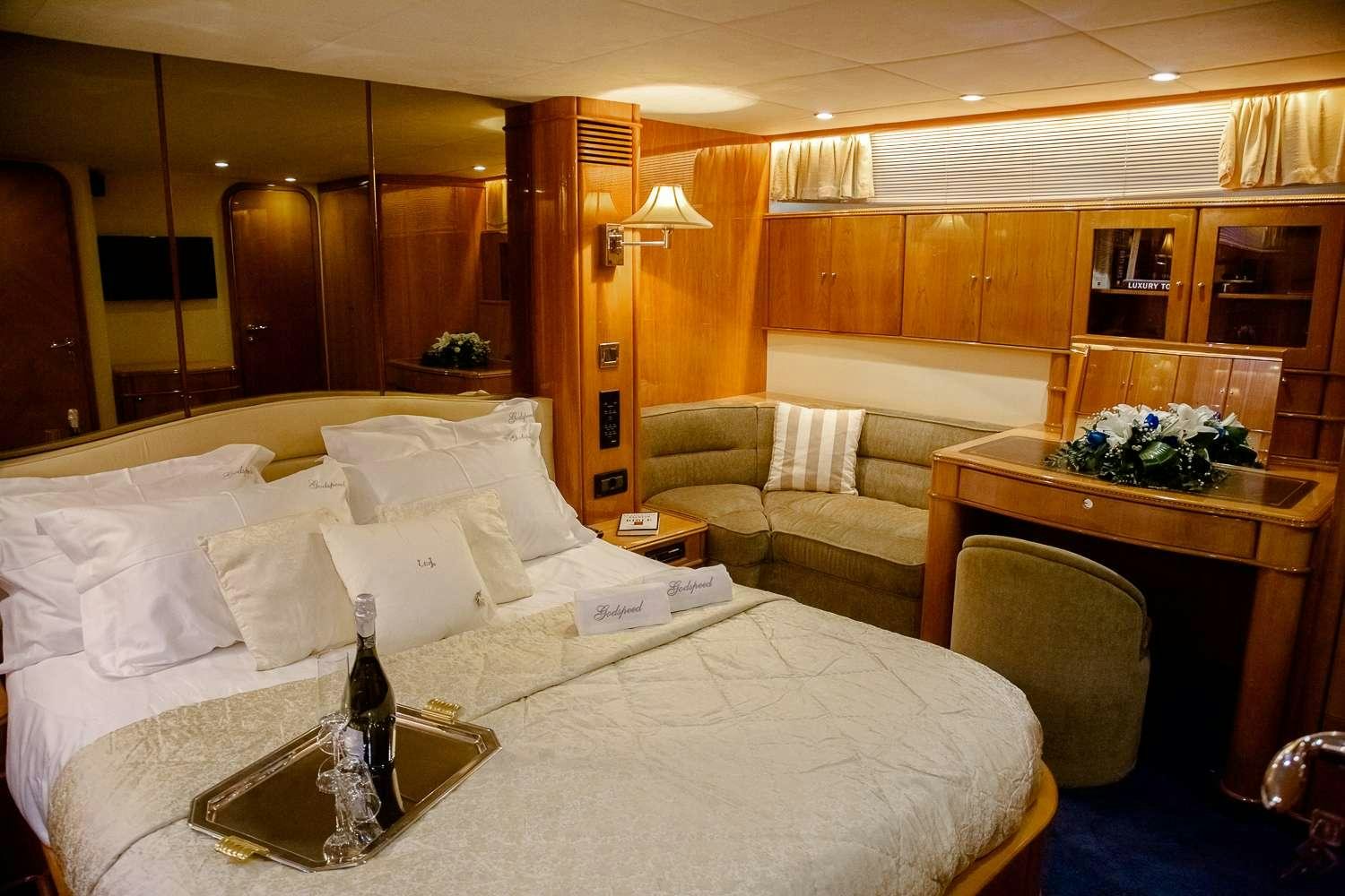 a room with a bed and a table aboard GODSPEED Yacht for Charter