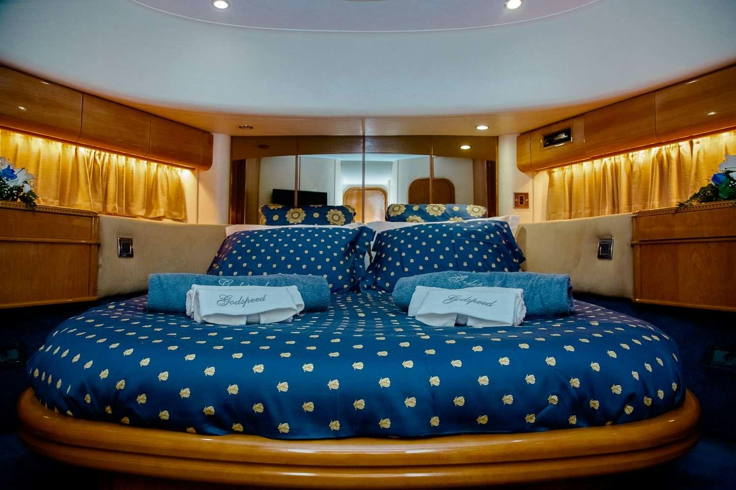 a bed with blue sheets aboard GODSPEED Yacht for Charter