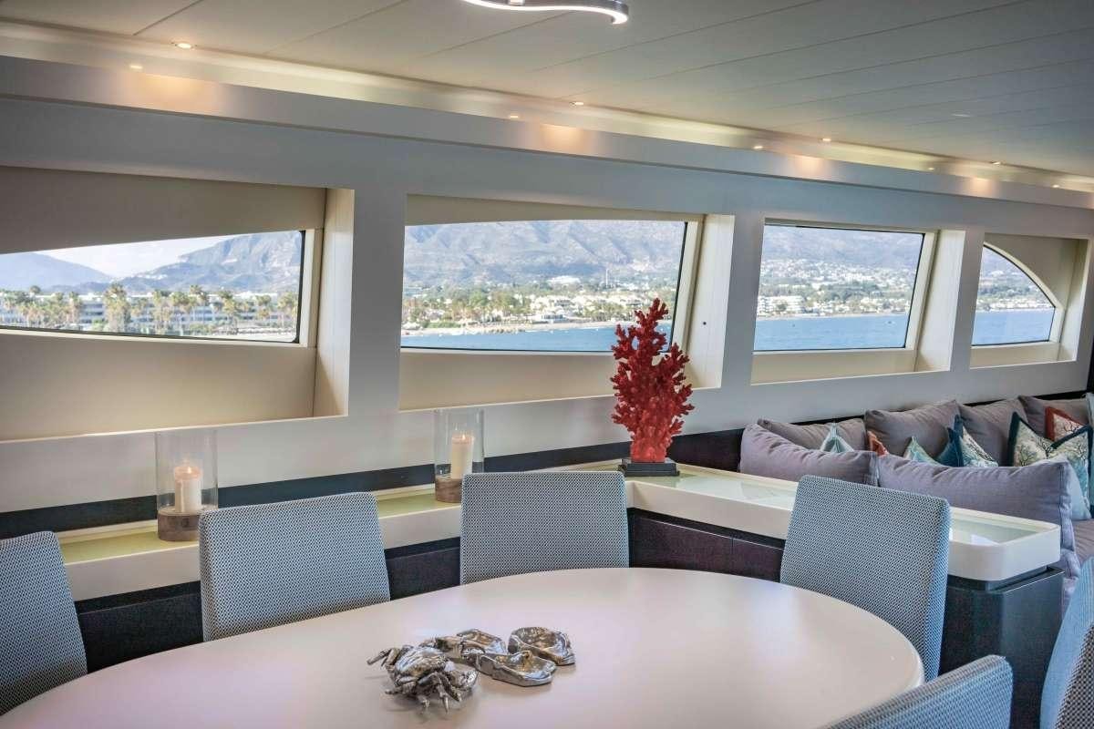 a room with a table and chairs aboard M Yacht for Charter