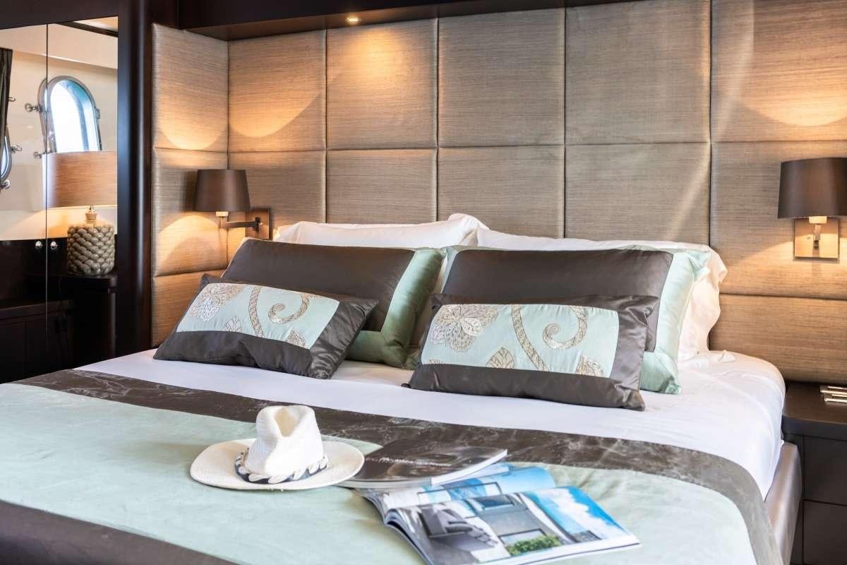 a bed with a white pillow and a white coffee cup on it aboard M Yacht for Charter