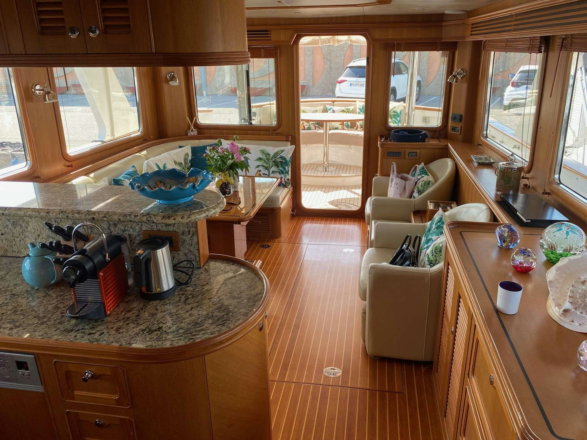 a kitchen with a countertop sink and a dining table aboard NOMADES Yacht for Charter