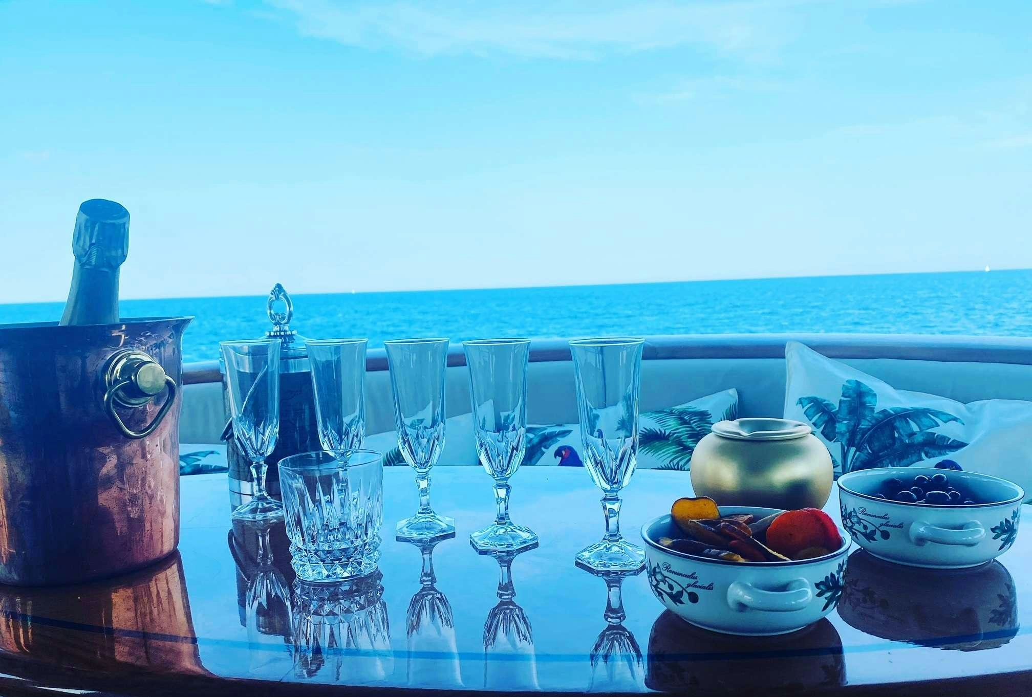 a table with wine glasses and food on it aboard NOMADES Yacht for Charter