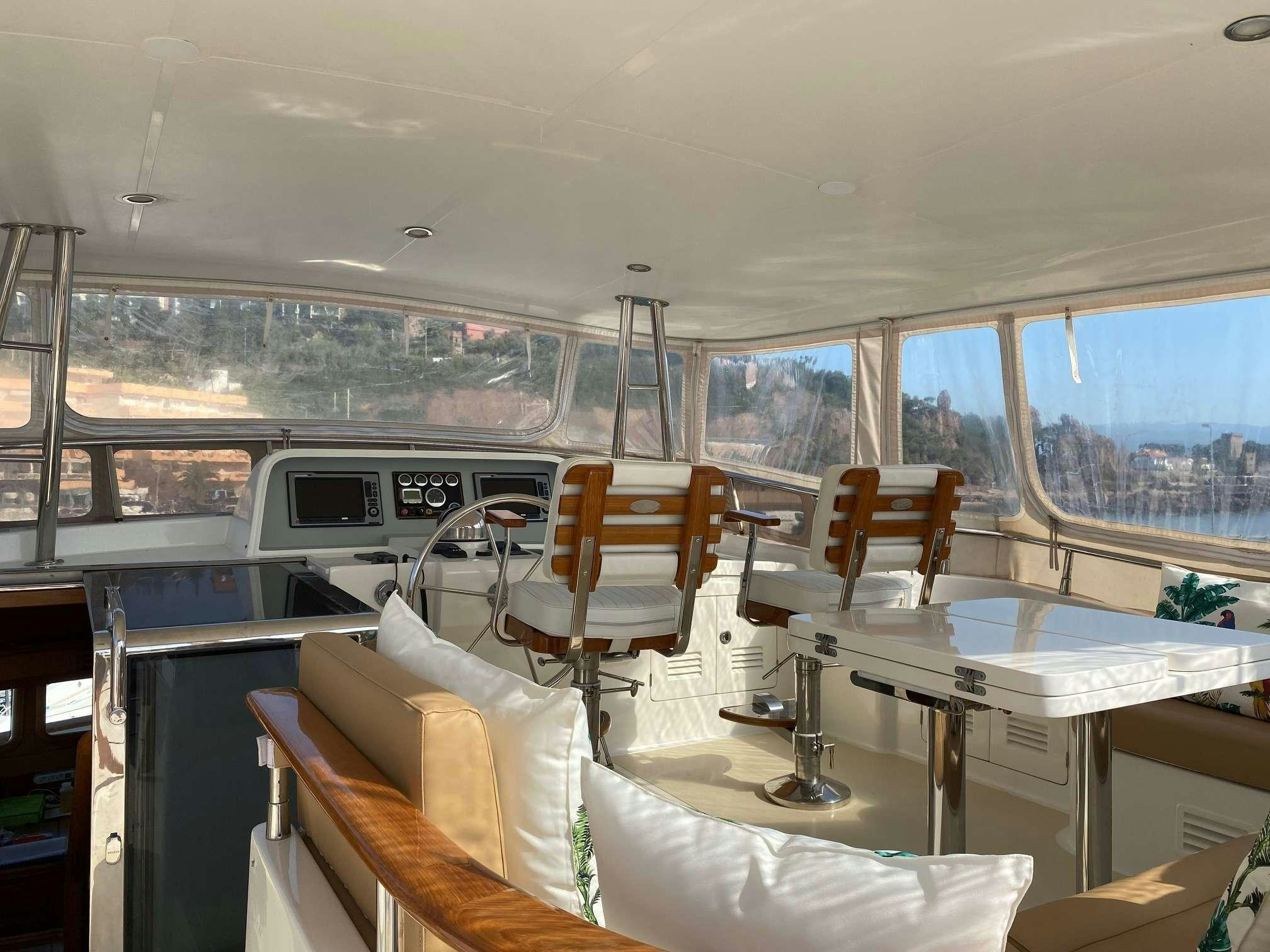 a room with a table chairs and a large window aboard NOMADES Yacht for Charter