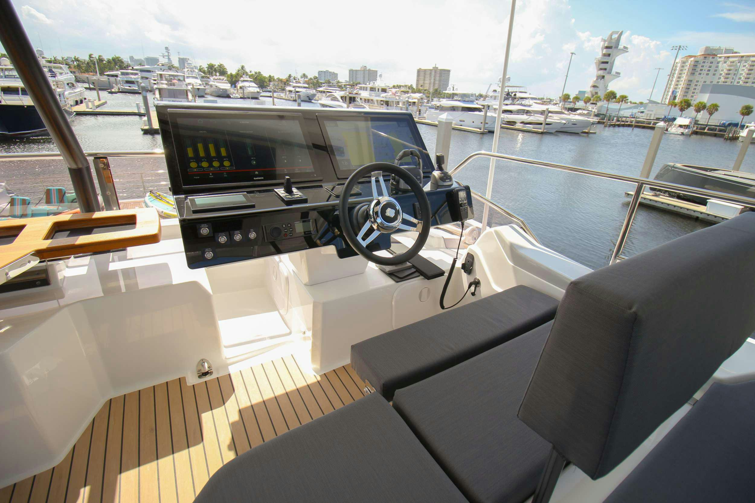 a boat with a steering wheel and a boat in the background aboard PRINCESS MILA Yacht for Charter