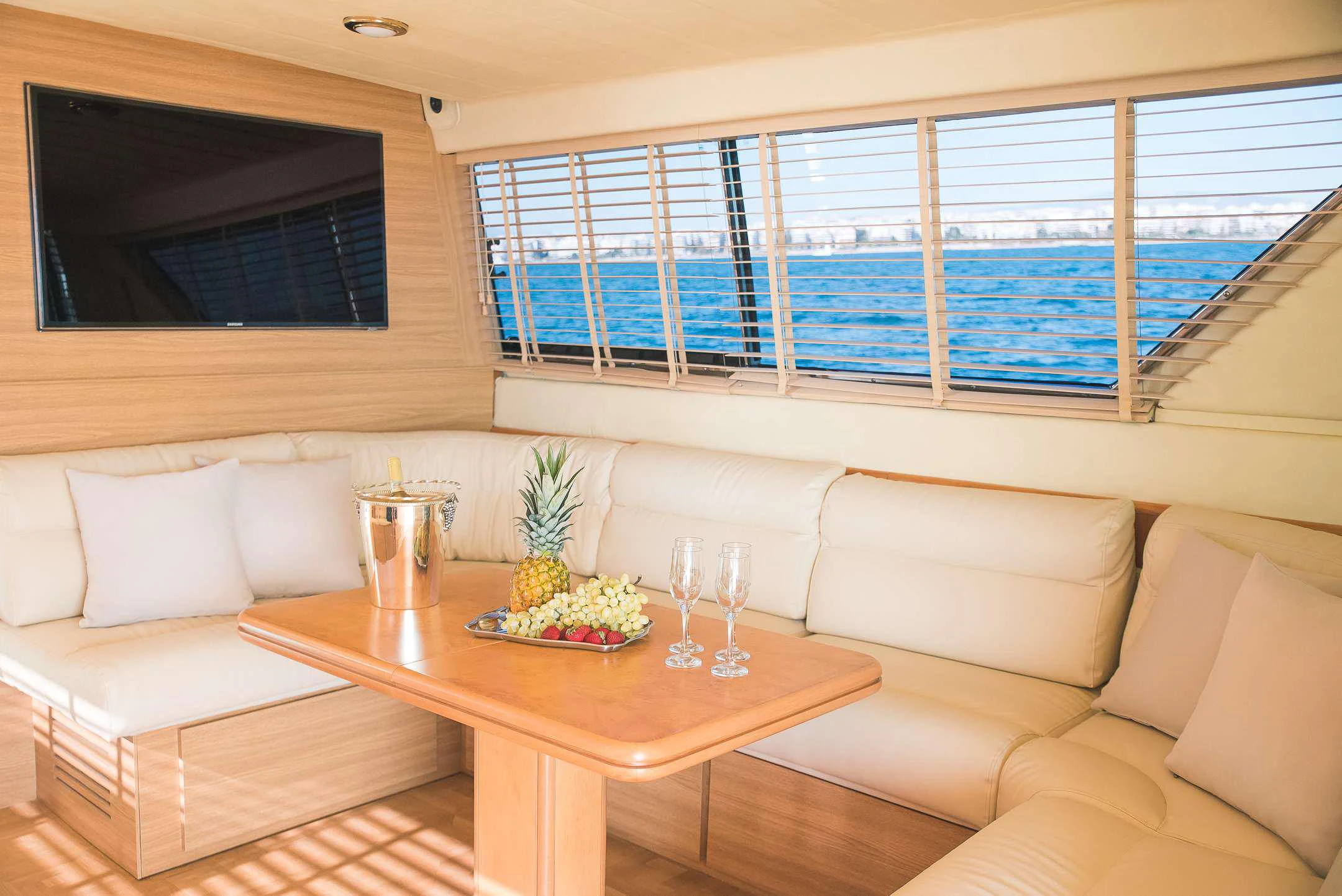 a living room with a table and couches aboard TEMPTATION Yacht for Charter