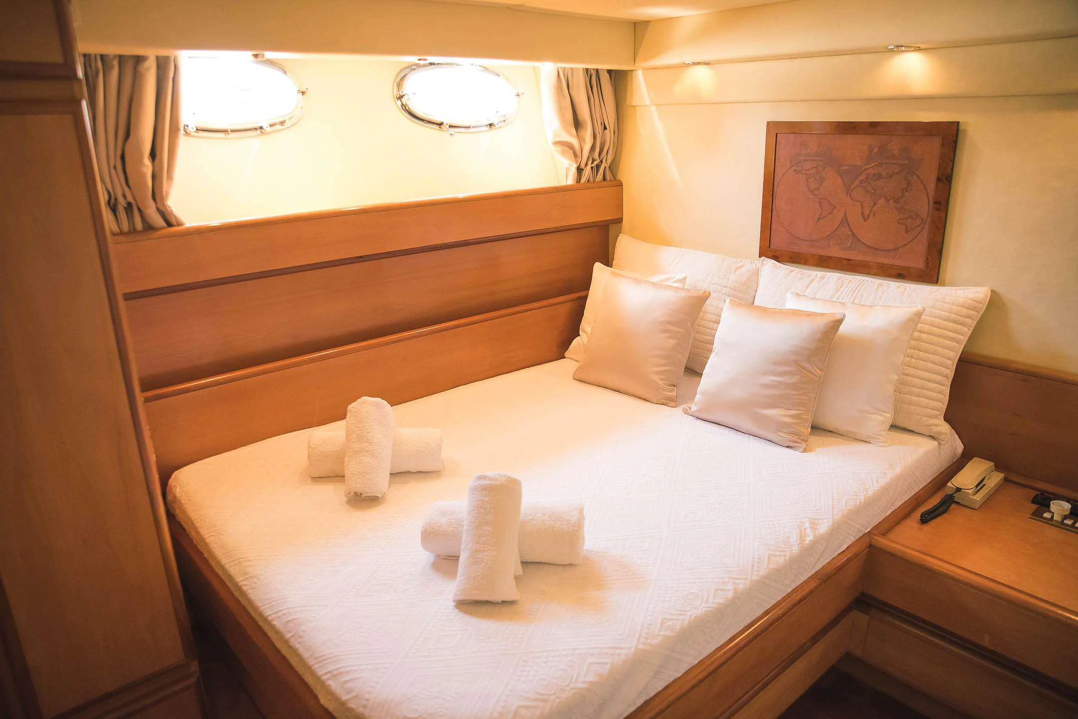 a bed with white sheets and pillows aboard TEMPTATION Yacht for Charter