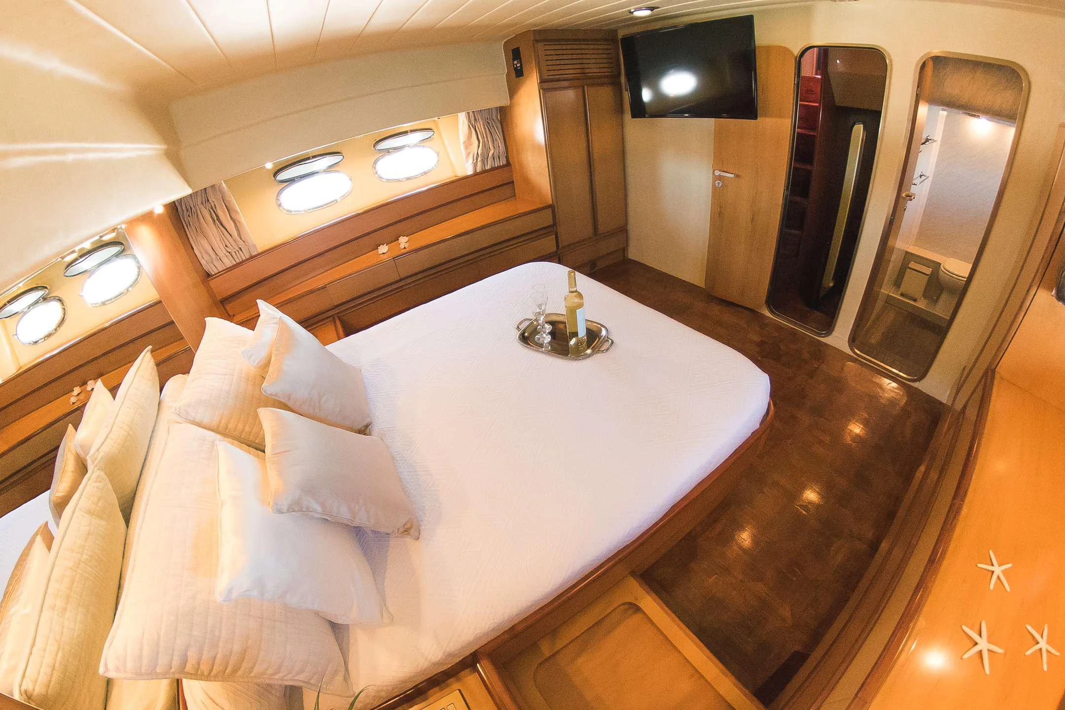 a bed with a white sheet aboard TEMPTATION Yacht for Charter