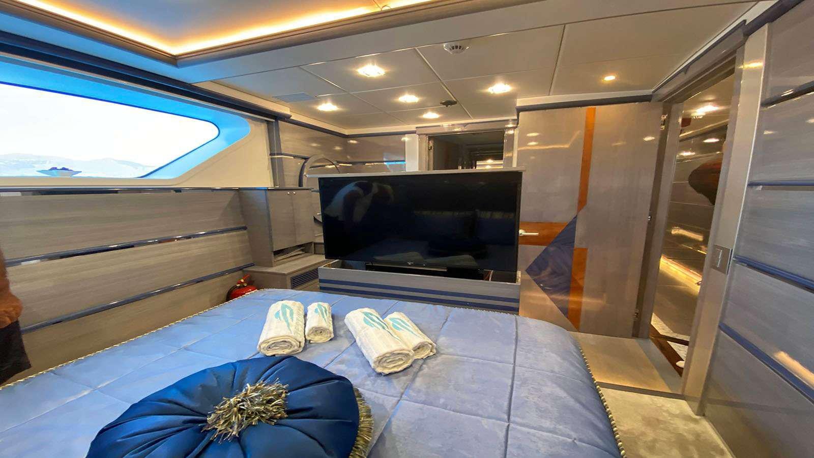 a room with a bed and a television aboard DESTINY Yacht for Charter