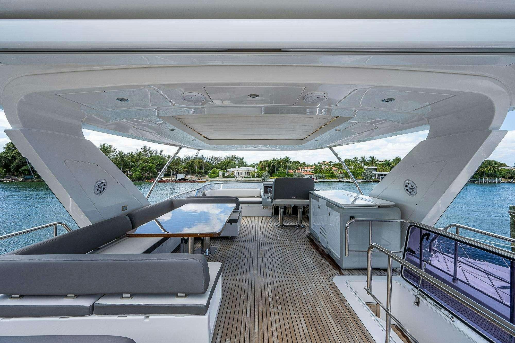 a deck with a pool and a deck with chairs and trees aboard STAYSEA Yacht for Charter