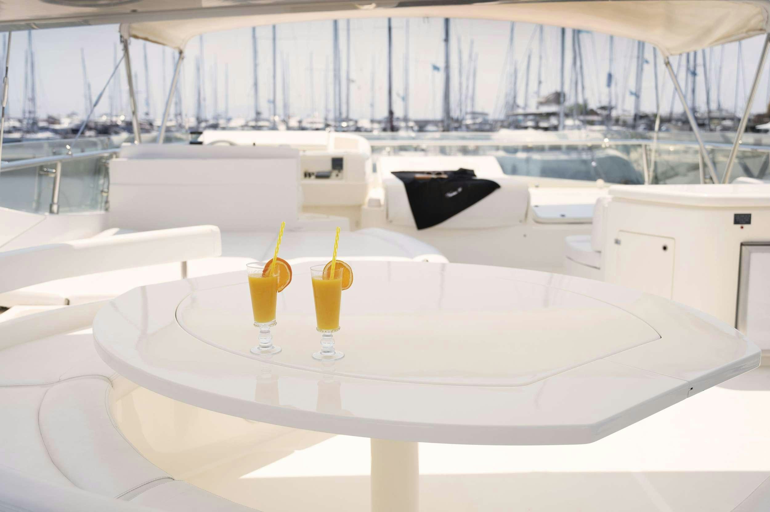 a glass of orange juice on a table with a glass of orange juice aboard VENTUS 21 Yacht for Charter