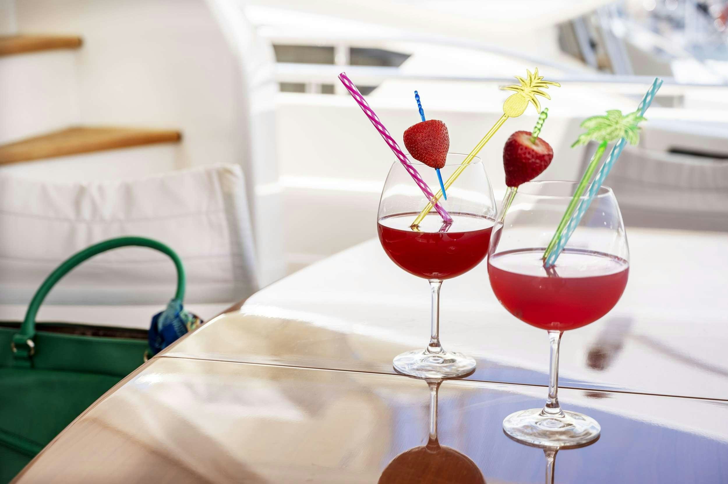 a couple of glasses with red liquid in them aboard VENTUS 21 Yacht for Charter