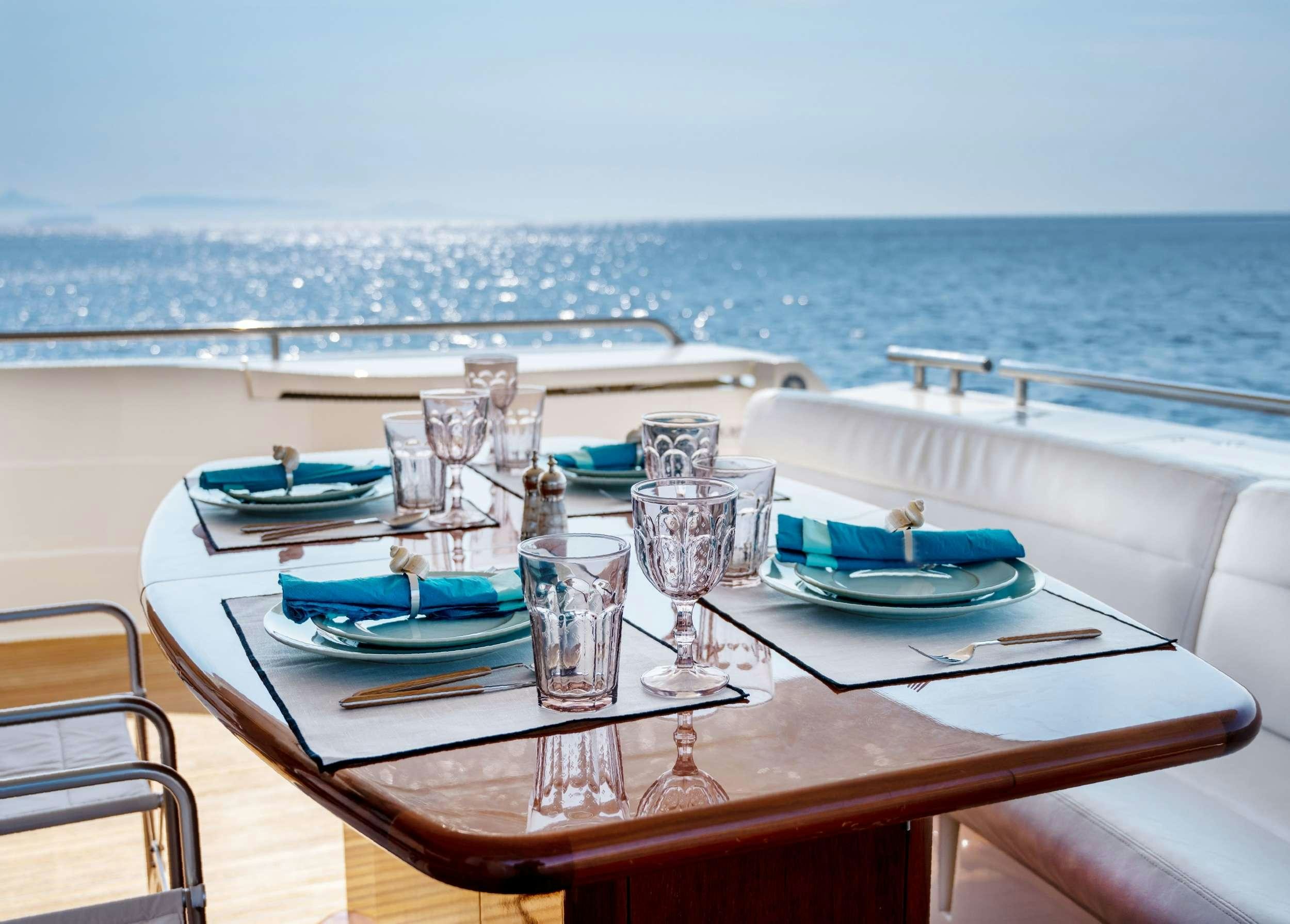 a table set for a dinner on a boat aboard VENTUS 21 Yacht for Charter