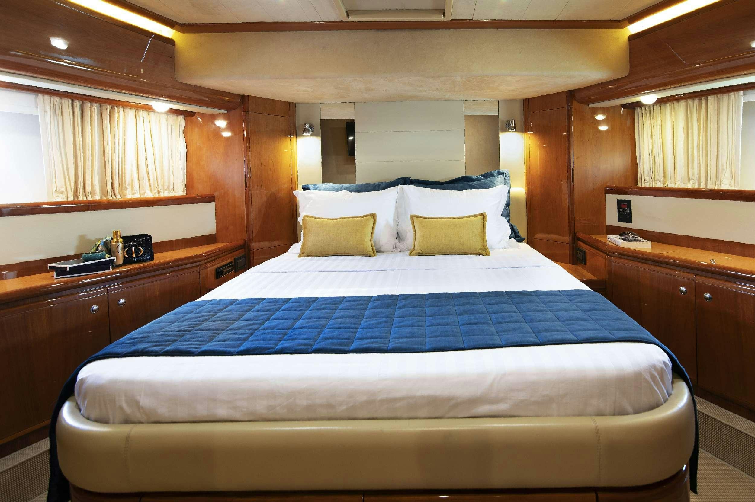 a bed with blue sheets aboard VENTUS 21 Yacht for Charter