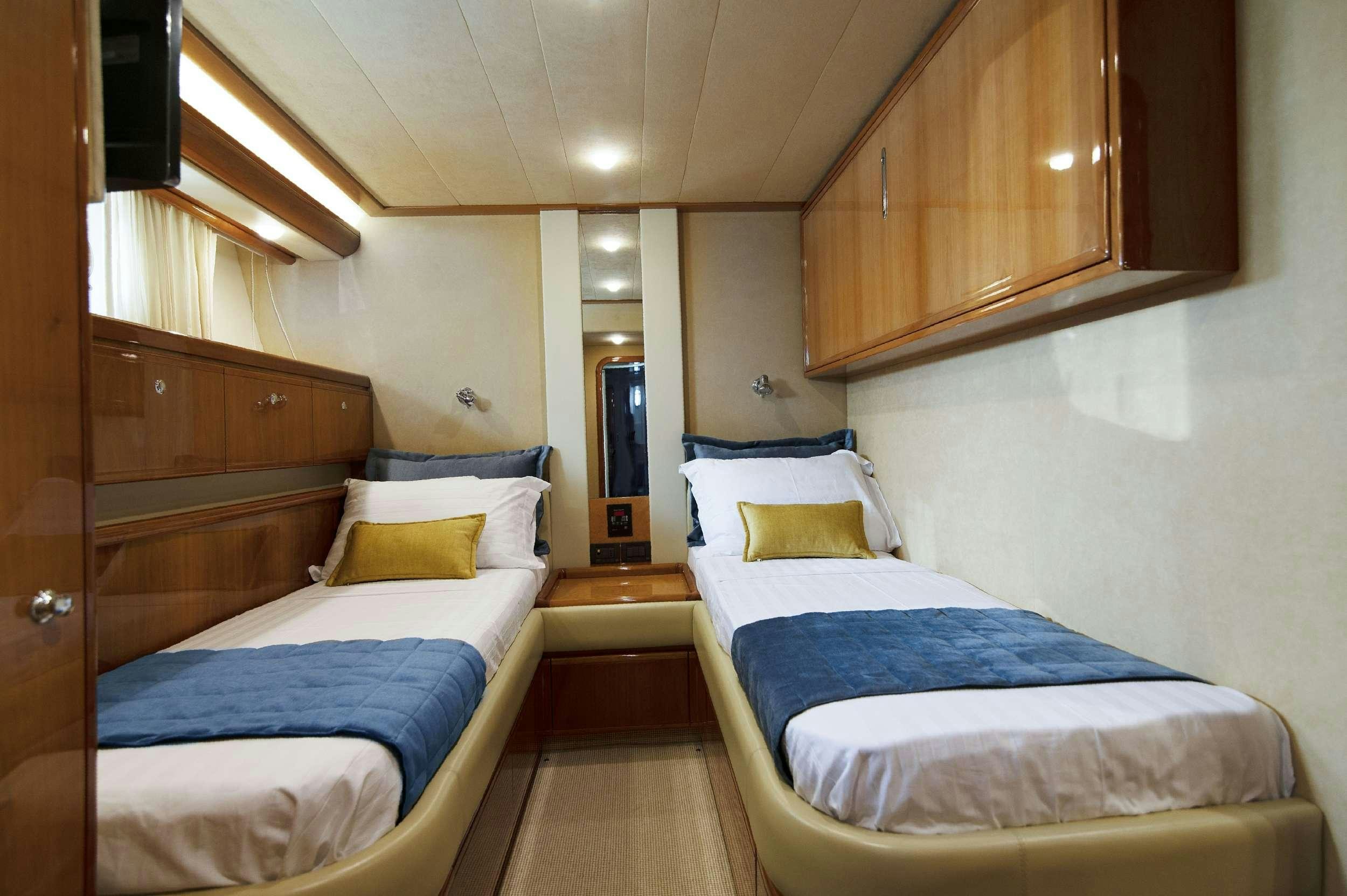 a room with beds and a dresser aboard VENTUS 21 Yacht for Charter