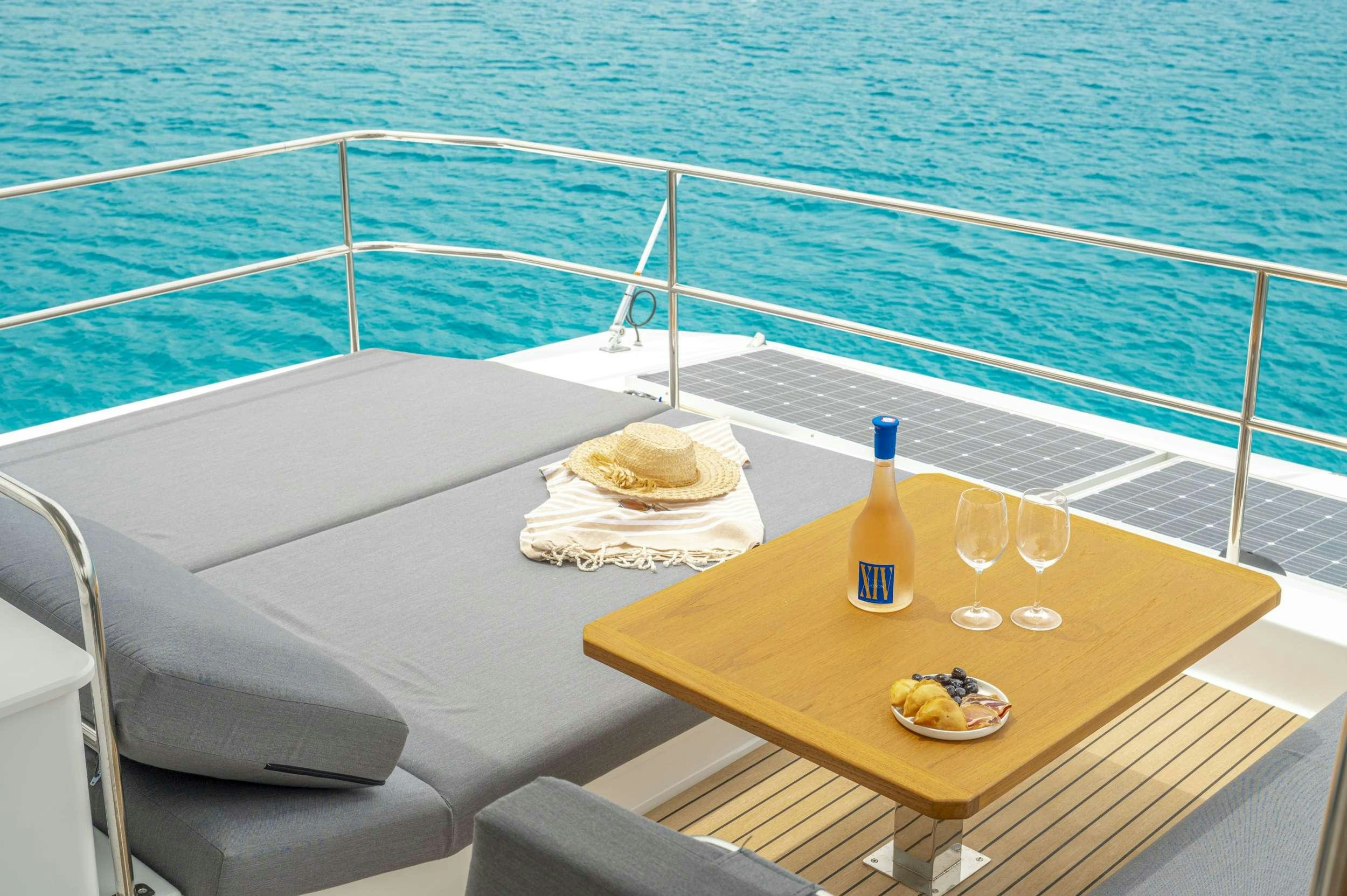 a table with a plate of food and a bottle of wine on it aboard SEMPER FIDELIS Yacht for Charter