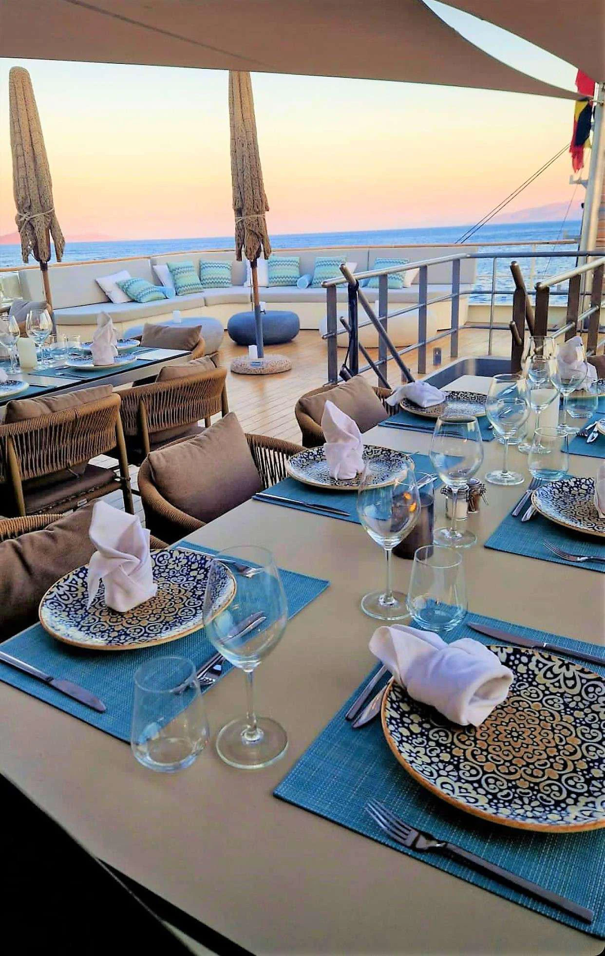 a table with food and glasses on it aboard ELYSIUM Yacht for Charter