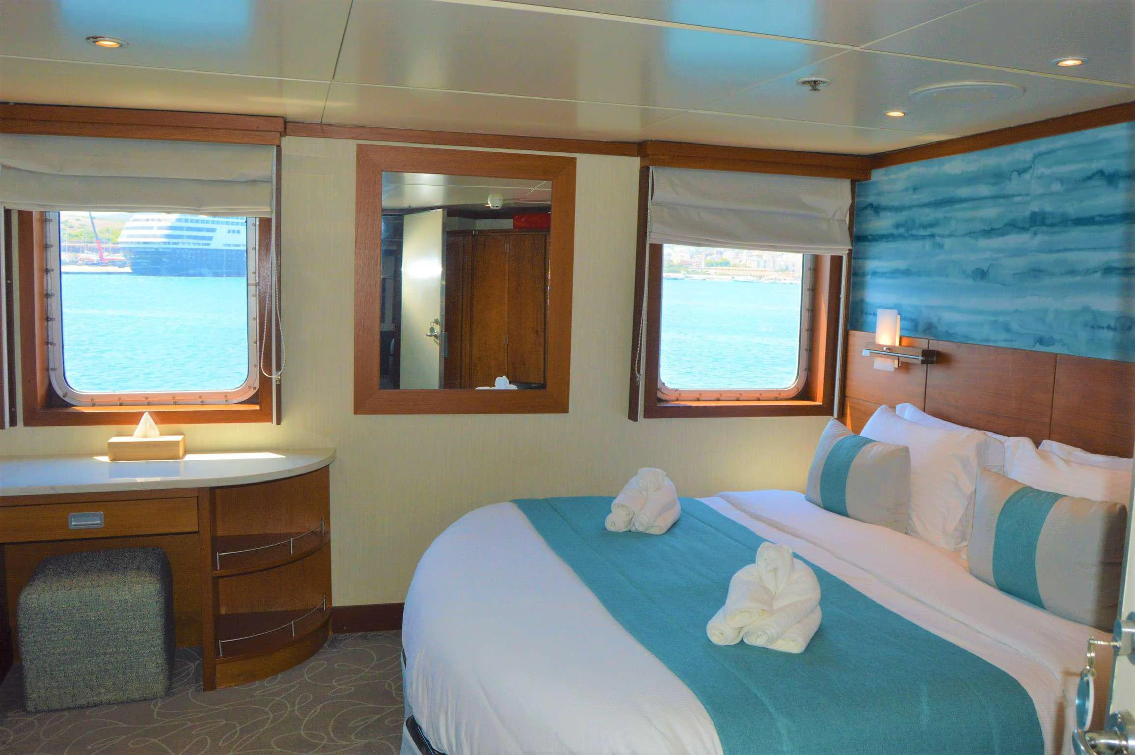 a bedroom with a bed and a desk aboard ELYSIUM Yacht for Charter