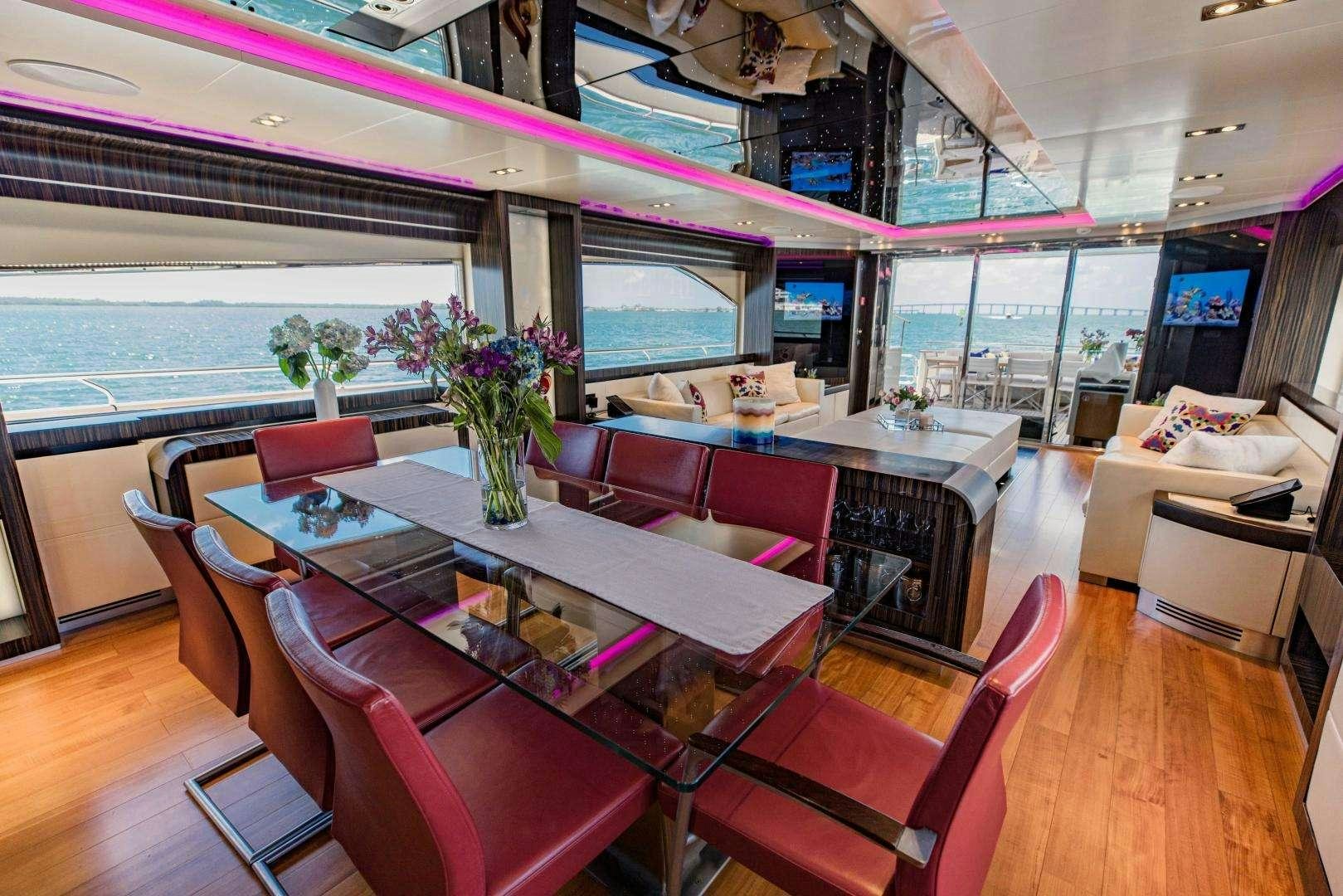 a room with a table chairs and a vase with flowers in it aboard 95 DOMINATOR Yacht for Charter