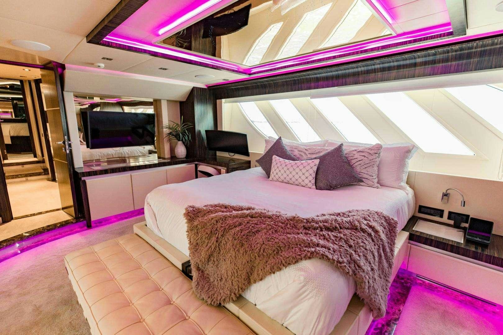 a bed with a pink comforter aboard 95 DOMINATOR Yacht for Charter