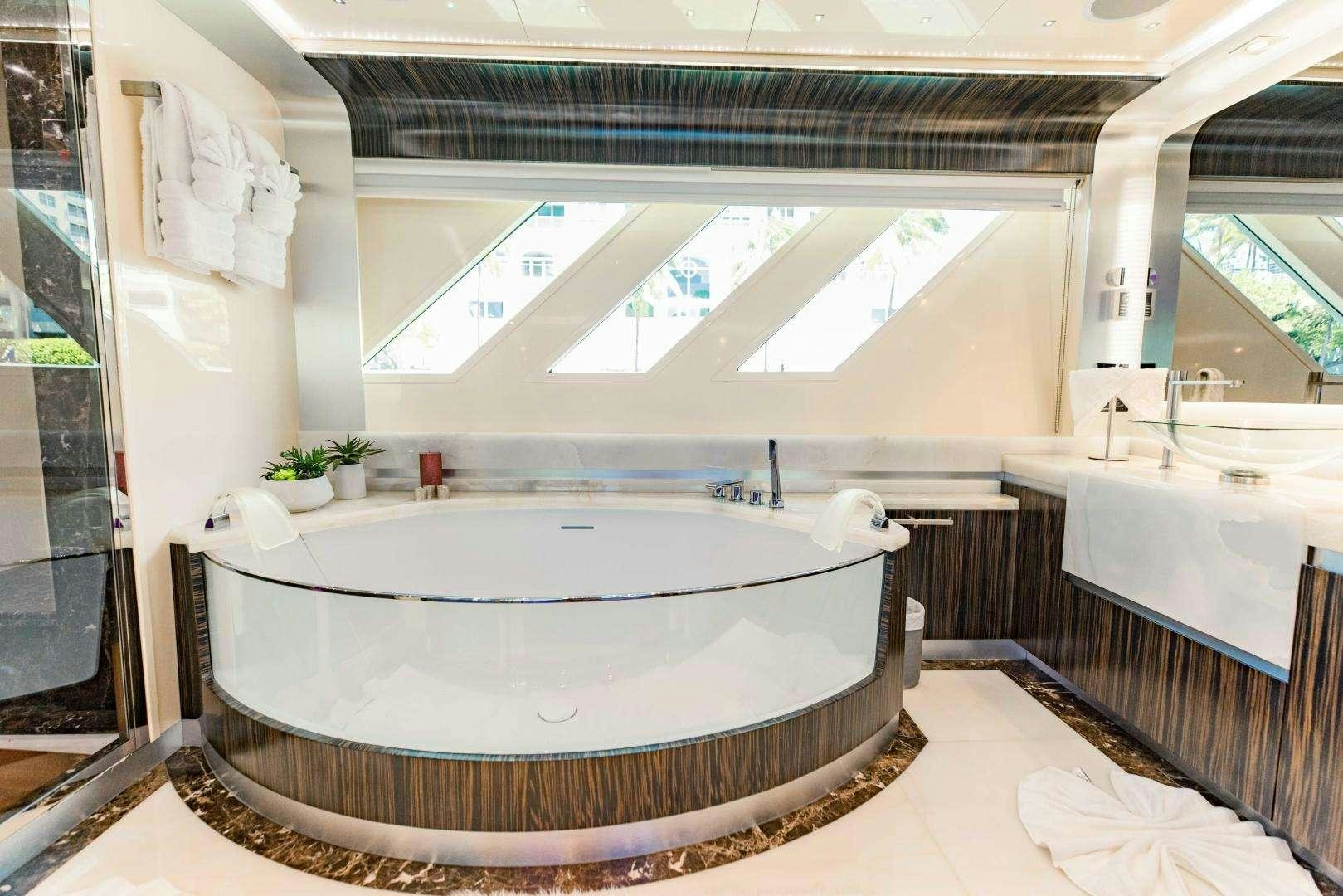 a large white bathtub in a bathroom aboard 95 DOMINATOR Yacht for Charter