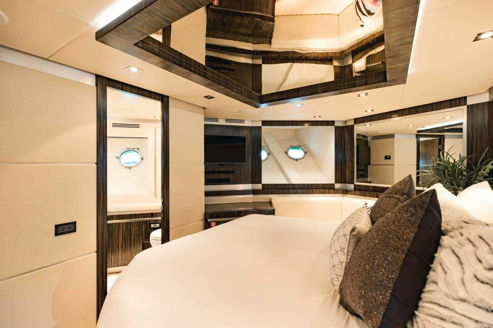 a room with a bed and a large window aboard 95 DOMINATOR Yacht for Charter