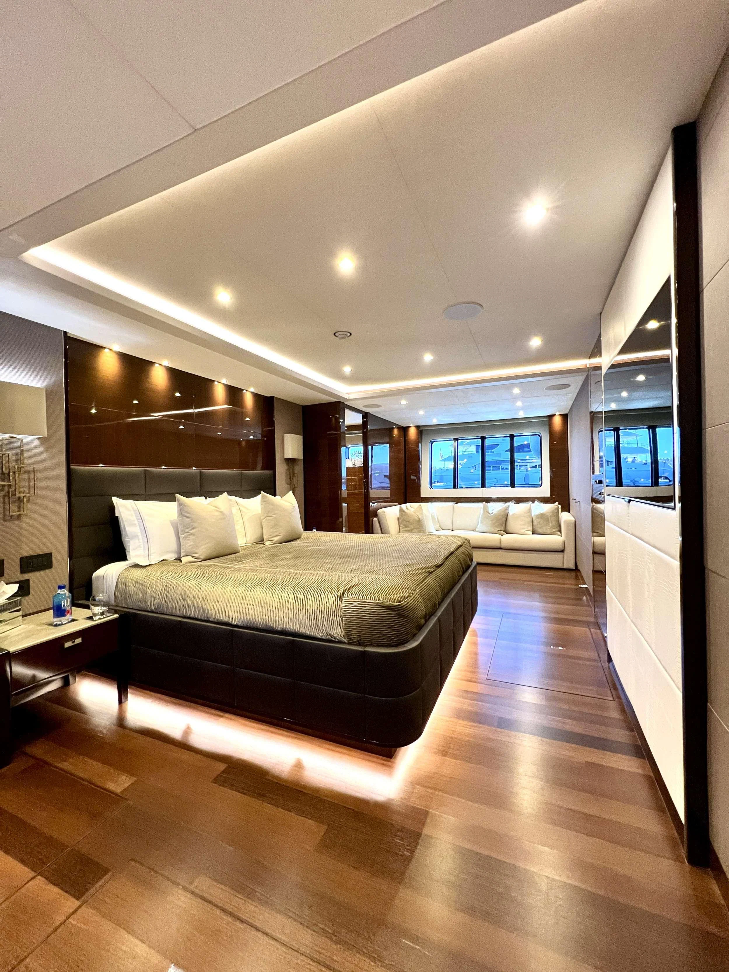 The master stateroom features a luxurious bed, ambient lighting, and elegant wood finishes. aboard LE VERSEAU Yacht for Charter