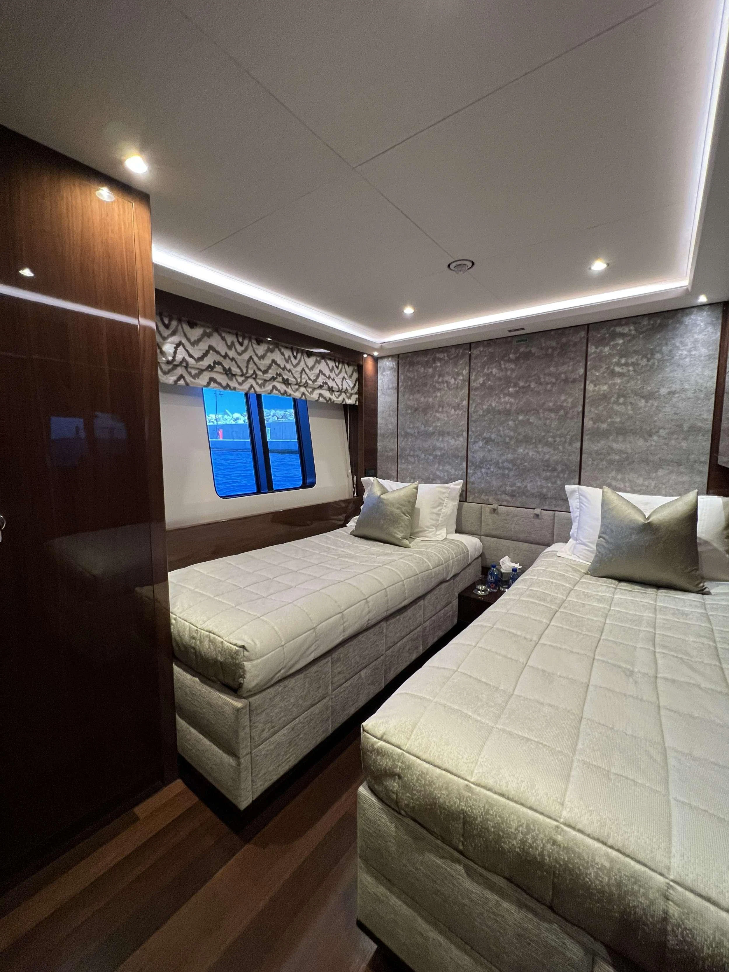 The guest stateroom features twin beds with luxurious bedding and elegant wood finishes. aboard LE VERSEAU Yacht for Charter