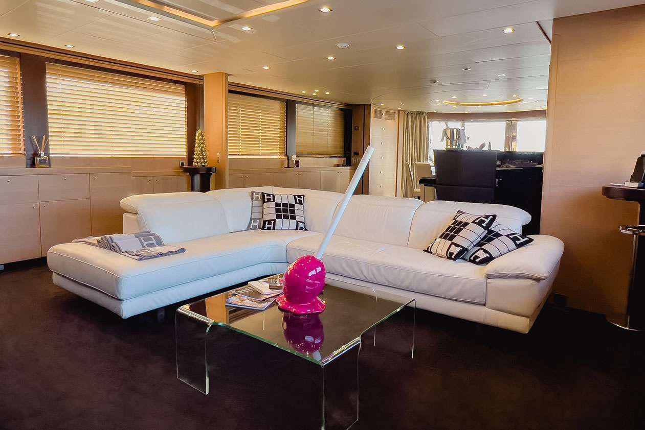 a living room with a couch and a coffee table aboard YCM 120 Yacht for Charter