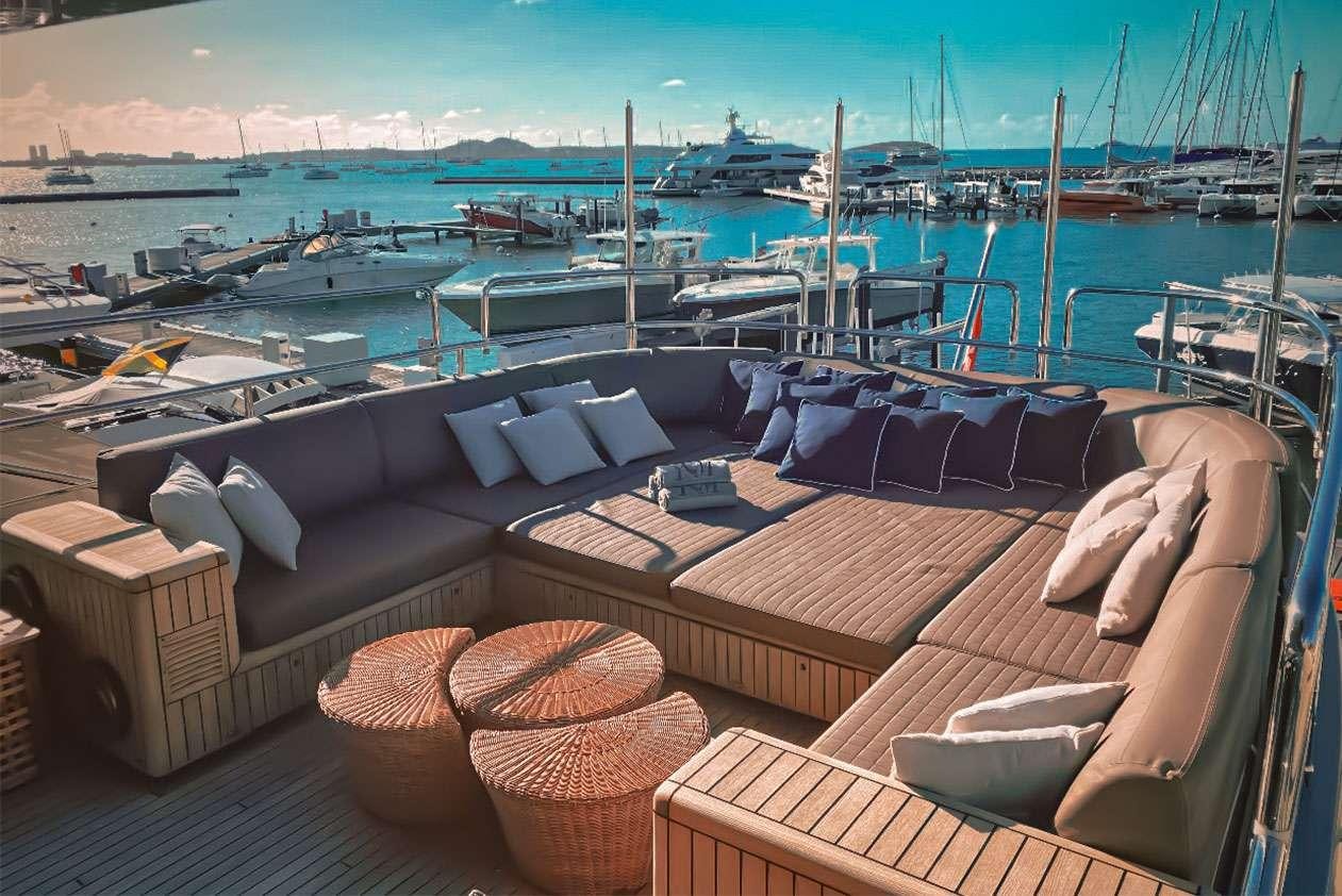 a deck with many chairs and boats aboard YCM 120 Yacht for Charter