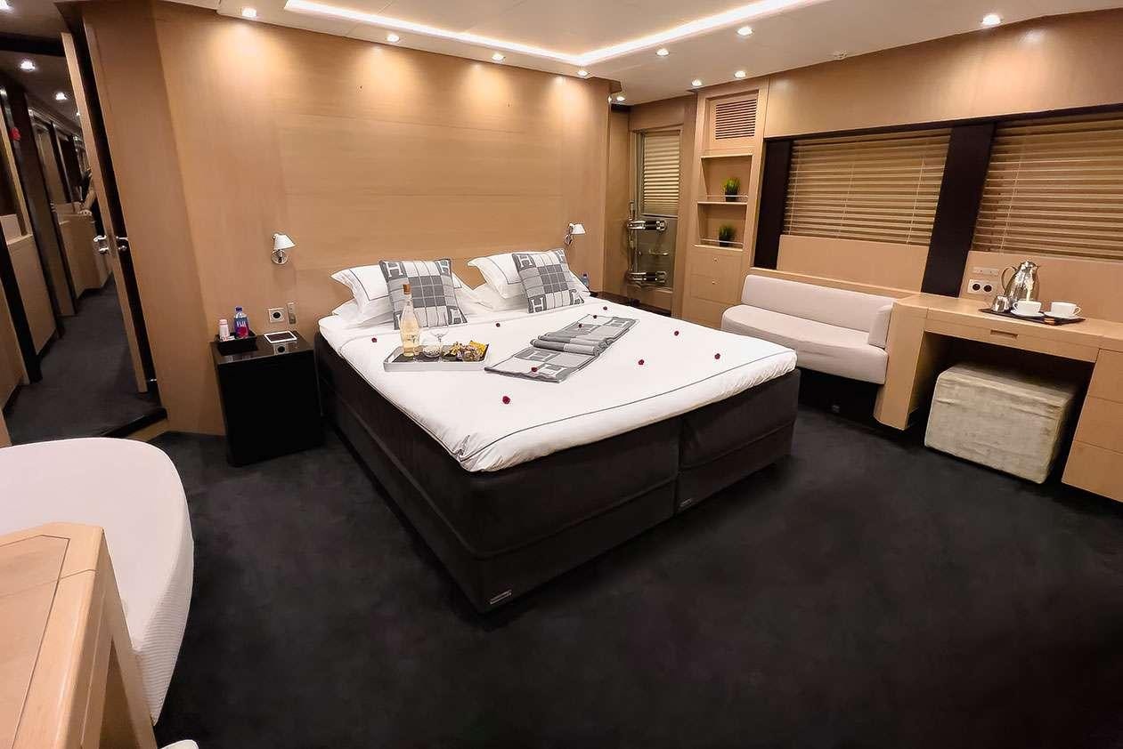 a hotel room with a bed and desk aboard YCM 120 Yacht for Charter