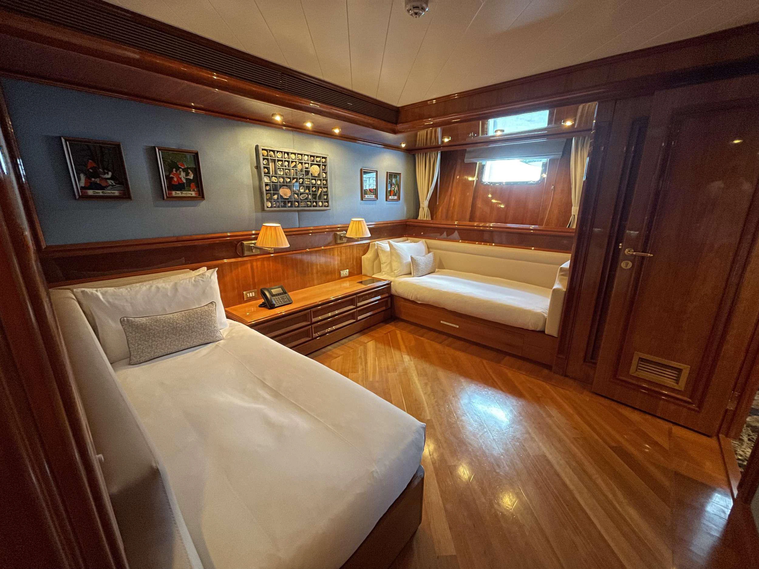 a bedroom with a bed and a wood cabinet aboard ISABELL PRINCESS OF THE SEA Yacht for Charter