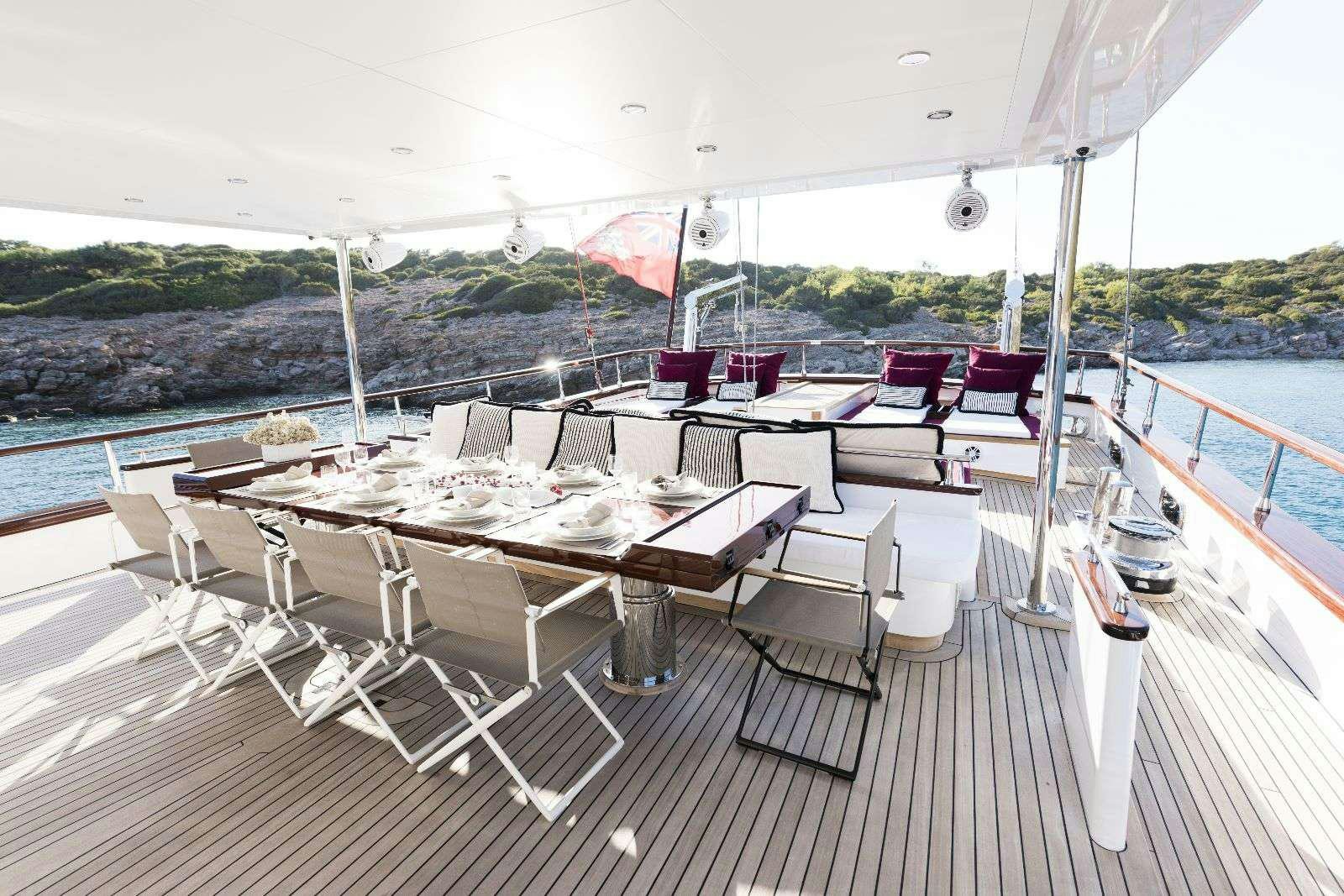 a deck with tables and chairs on it aboard THAT'S AMORE Yacht for Charter