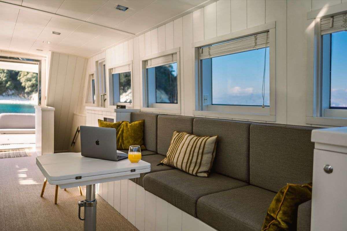 a living room with a laptop on a table aboard FLAMENGA Yacht for Charter