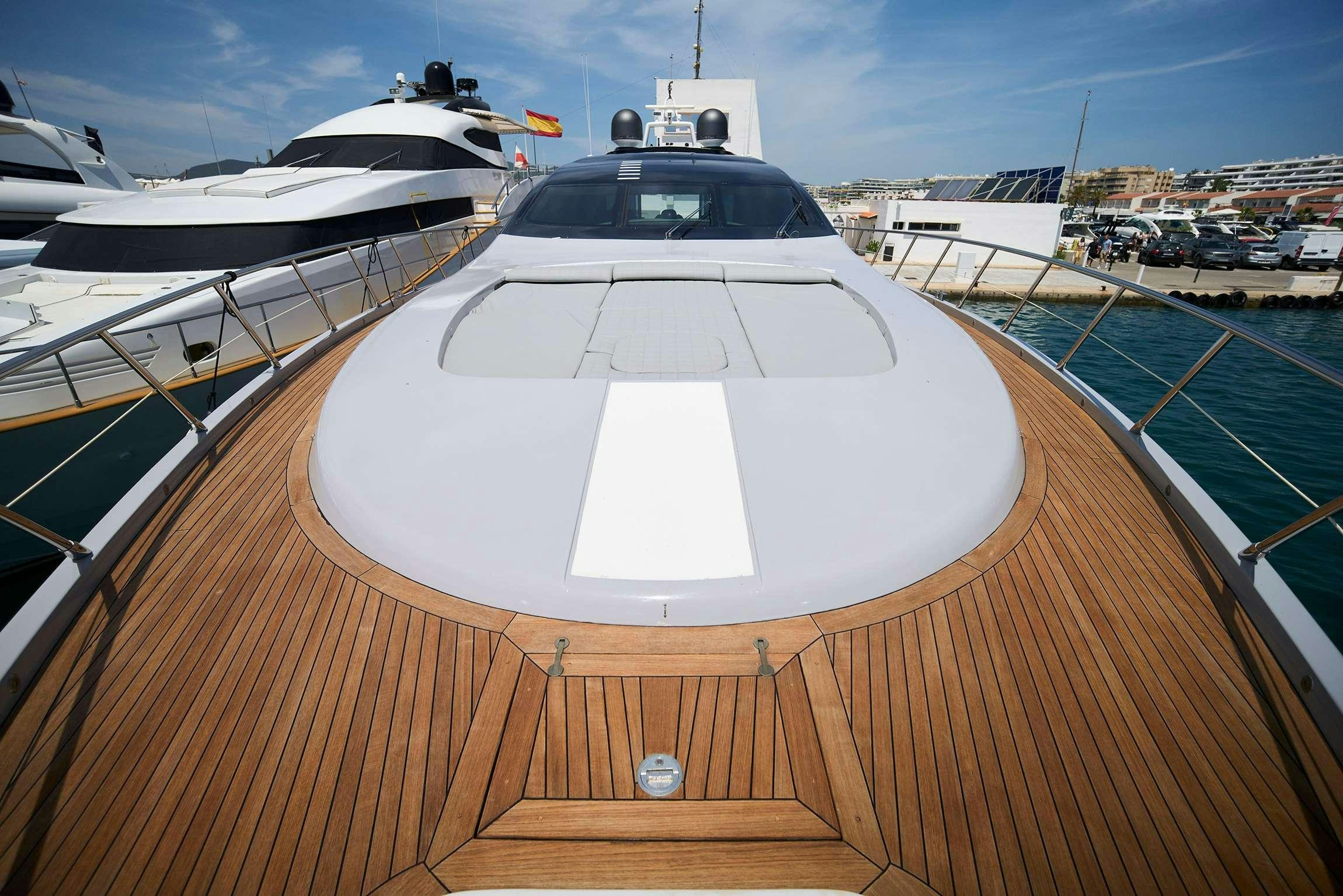a deck with a large yacht in the background aboard FIVE STARS Yacht for Charter