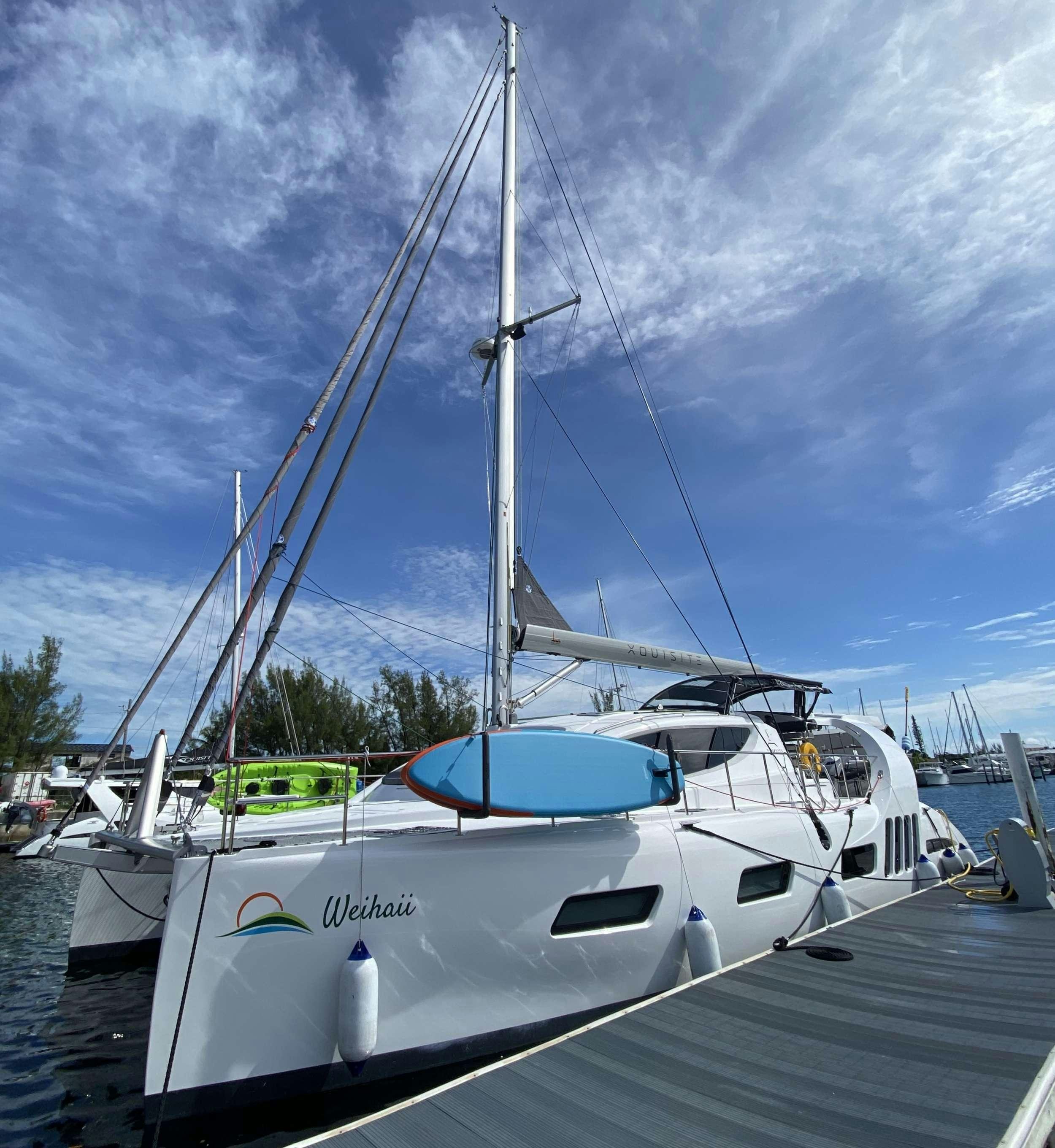 a white boat in a harbor aboard WEIHAII Yacht for Charter