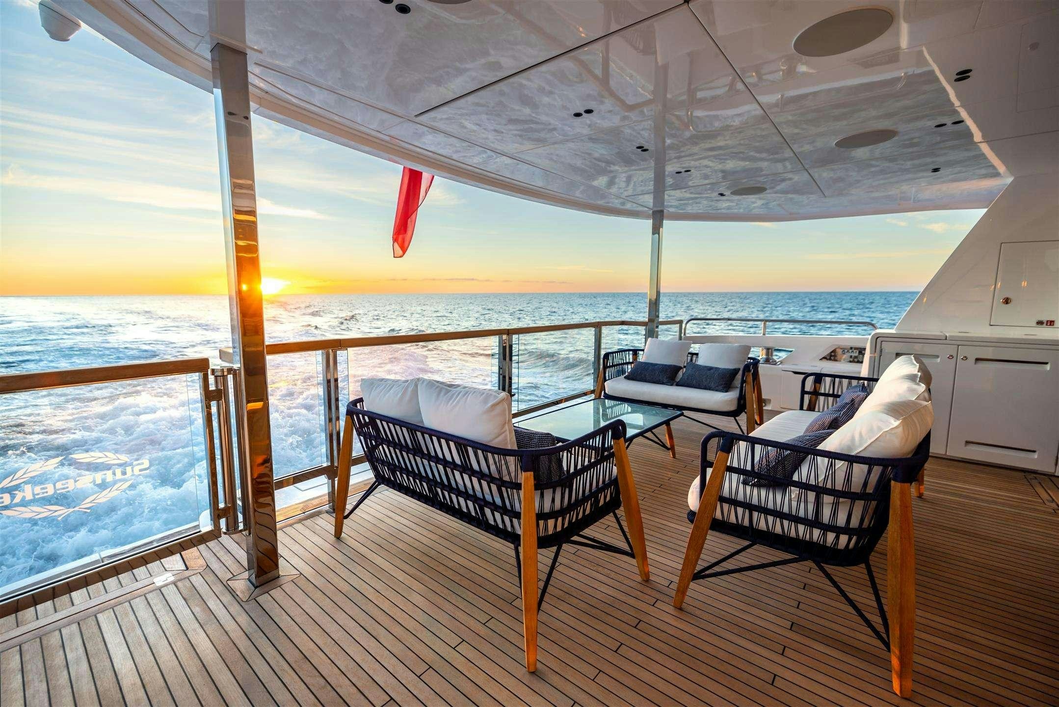 a deck with chairs and a table on it aboard MY SCORPION Yacht for Charter