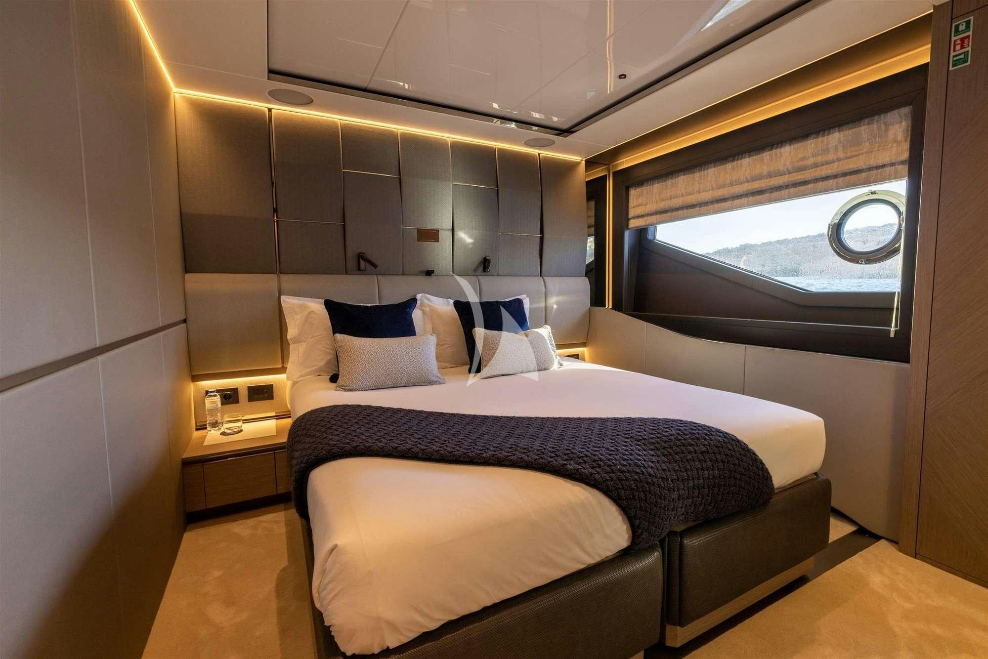 a bed with a blue and white blanket on it aboard MY SCORPION Yacht for Charter