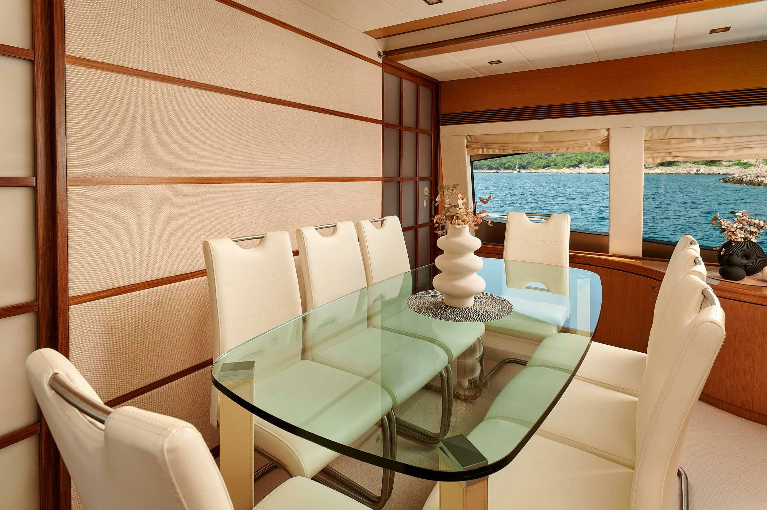 a room with a table chairs and a window aboard STELLA D'ORO Yacht for Charter