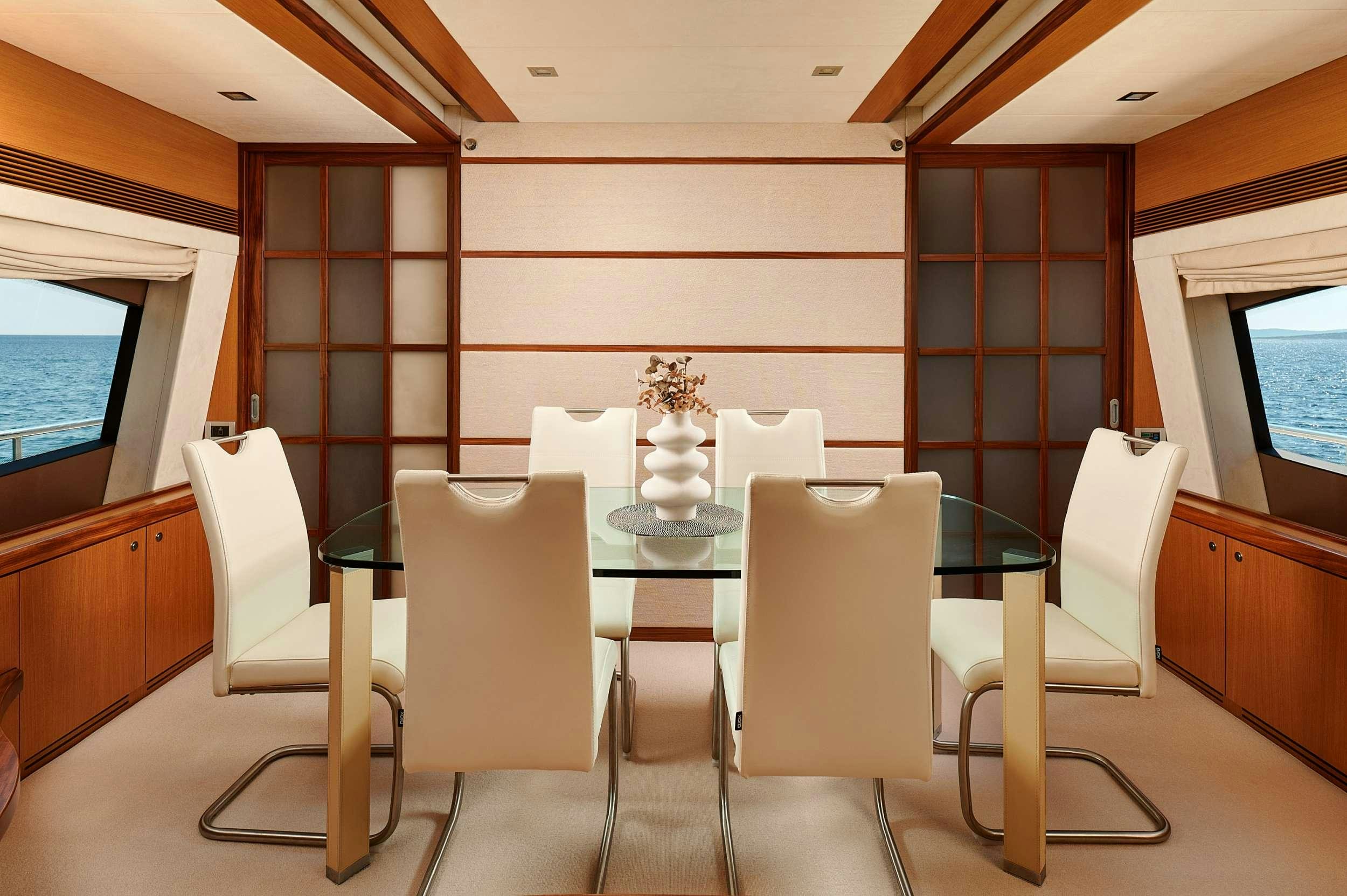 a room with a table chairs and a window aboard STELLA D'ORO Yacht for Charter