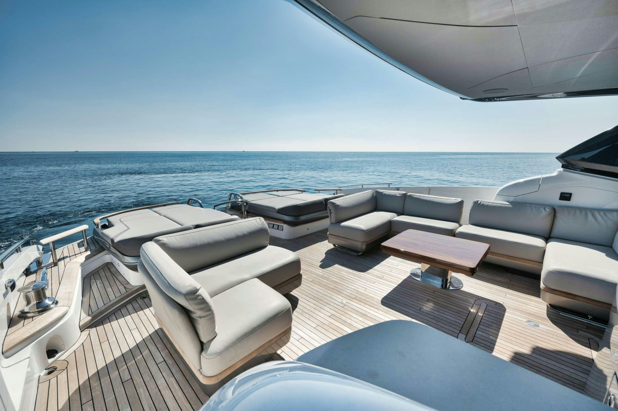 a deck with chairs and a body of water aboard HOOKED HER Yacht for Charter