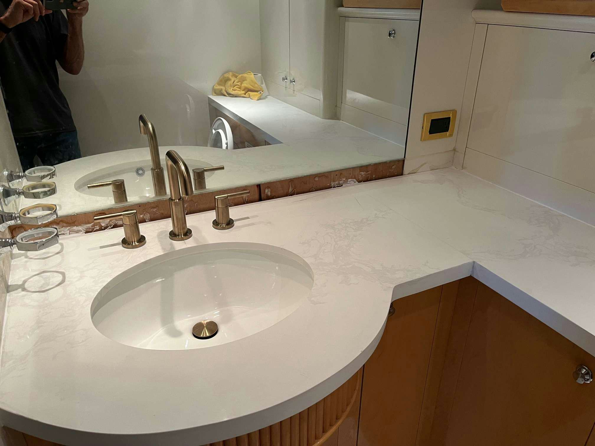 a bathroom sink with a large mirror aboard STEELING TIME Yacht for Charter