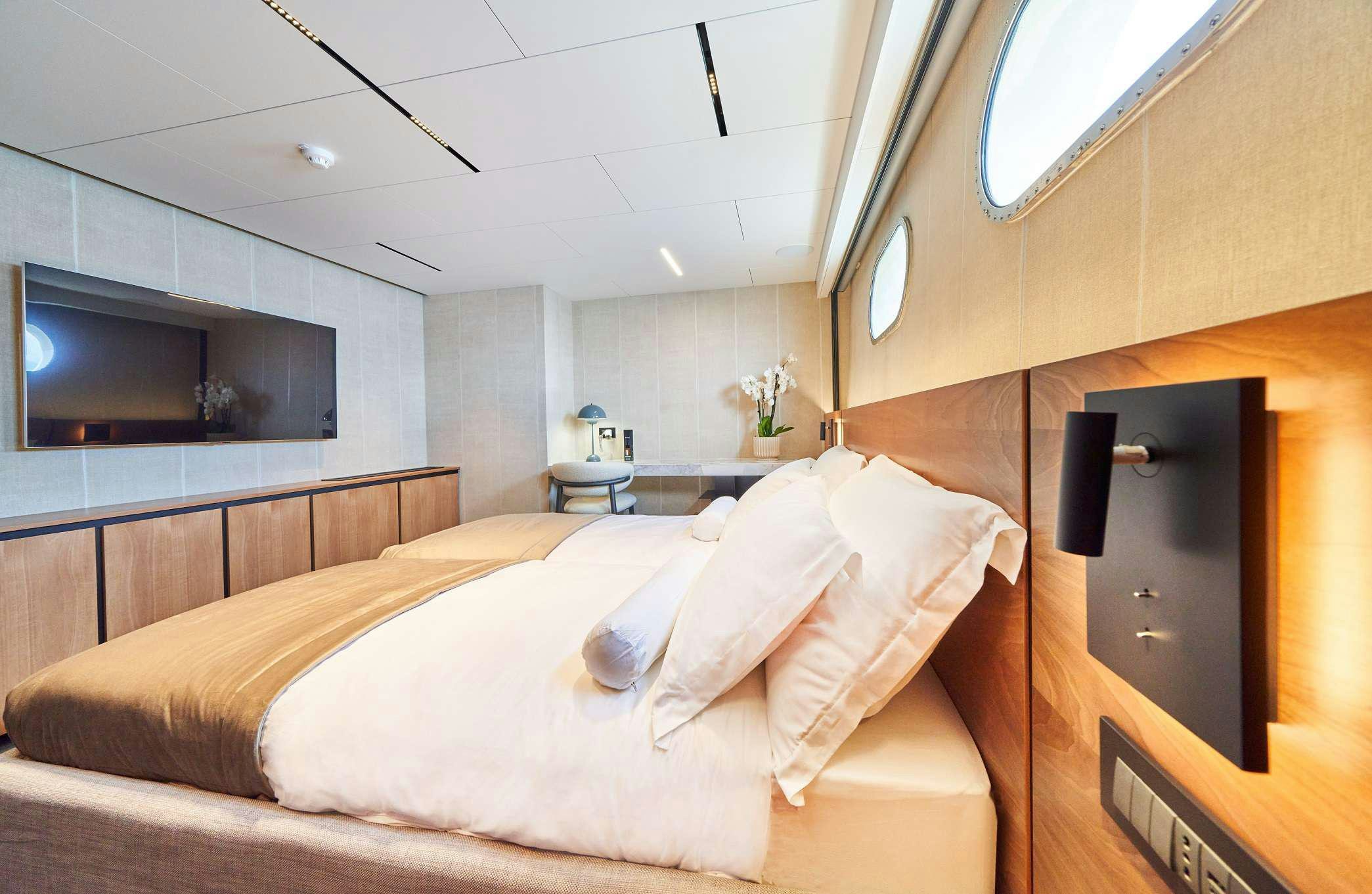 a room with a bed and a television aboard MARALLURE Yacht for Charter