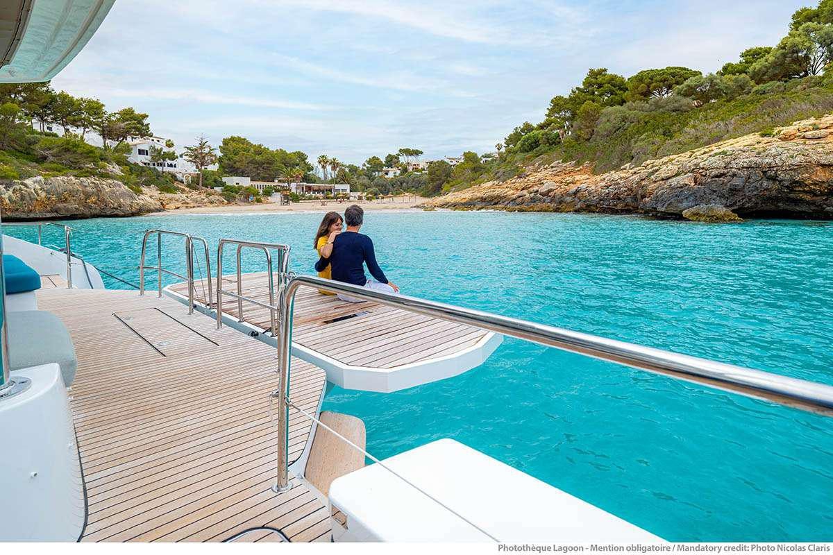 a man and woman sitting on a boat in the water aboard VALINOR Yacht for Charter