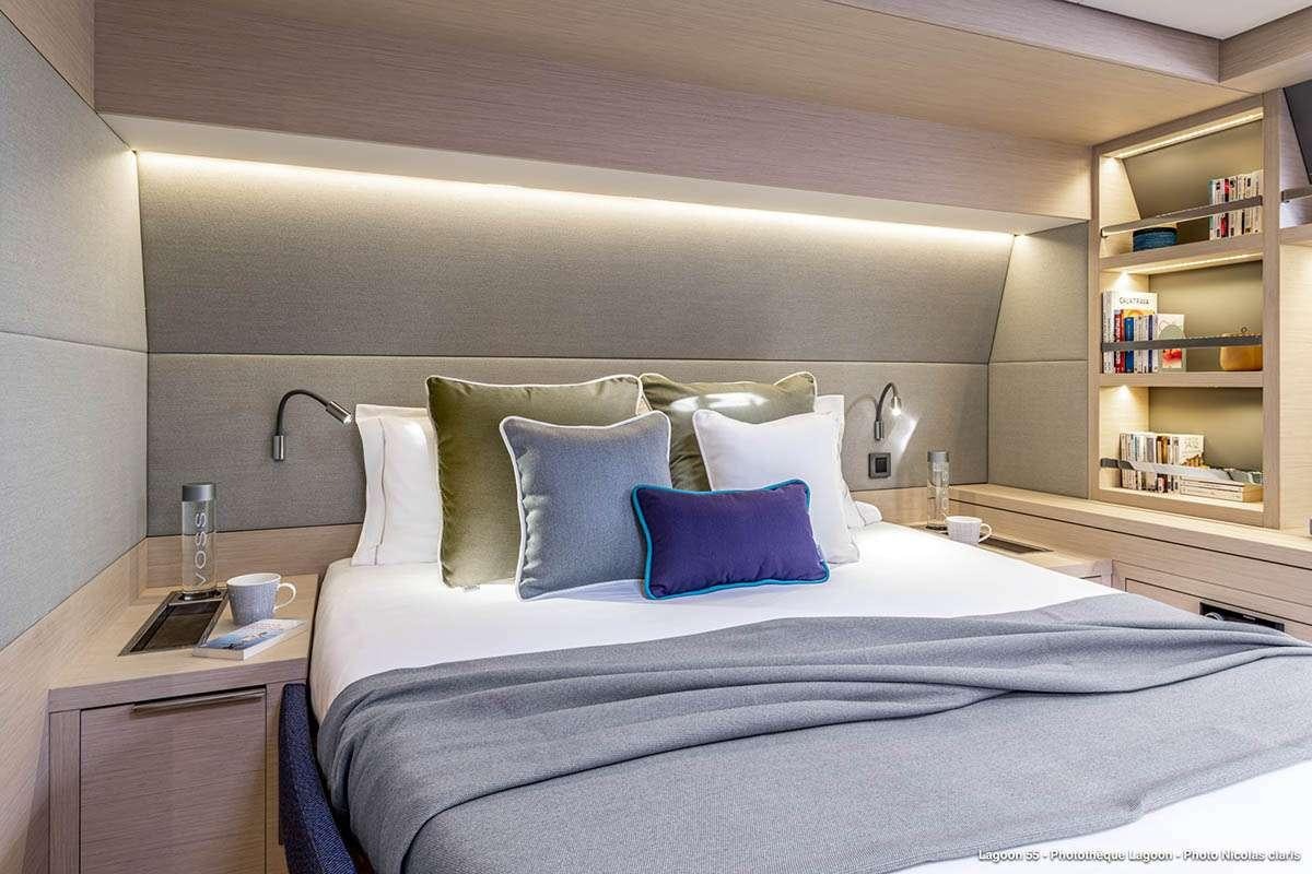 a bed with blue and white pillows aboard VALINOR Yacht for Charter