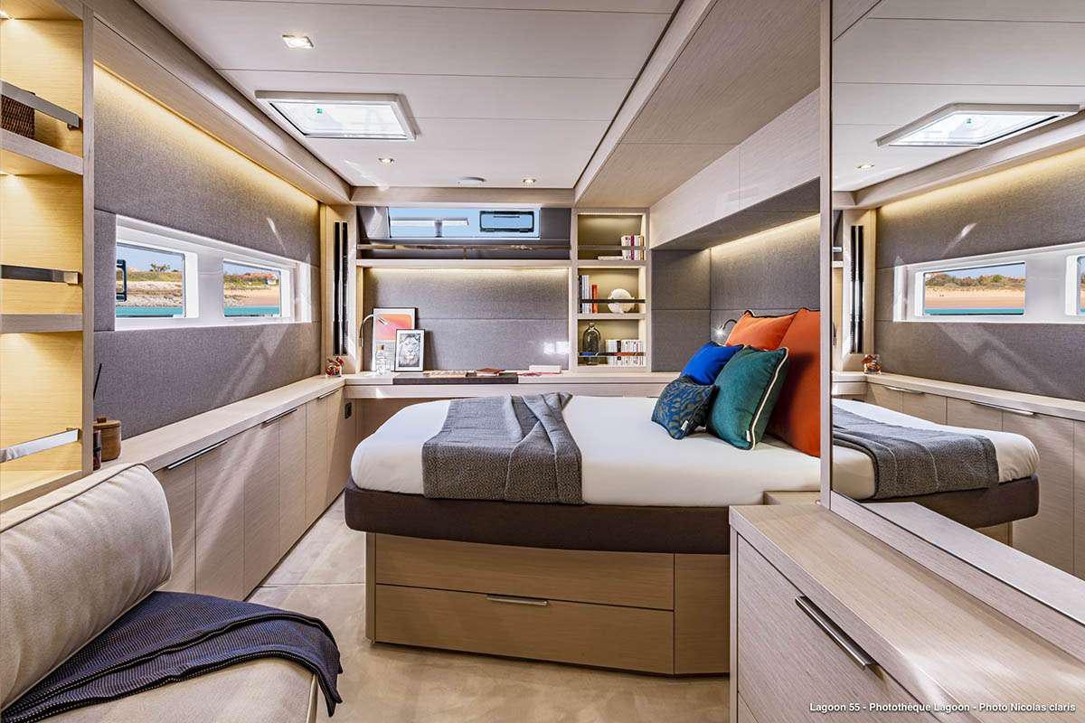 a room with a couch and a shelf with books on it aboard VALINOR Yacht for Charter