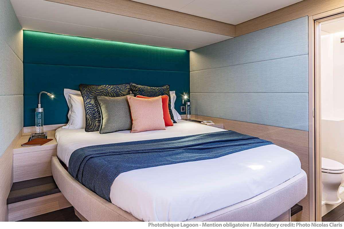 a bed with blue sheets aboard VALINOR Yacht for Charter
